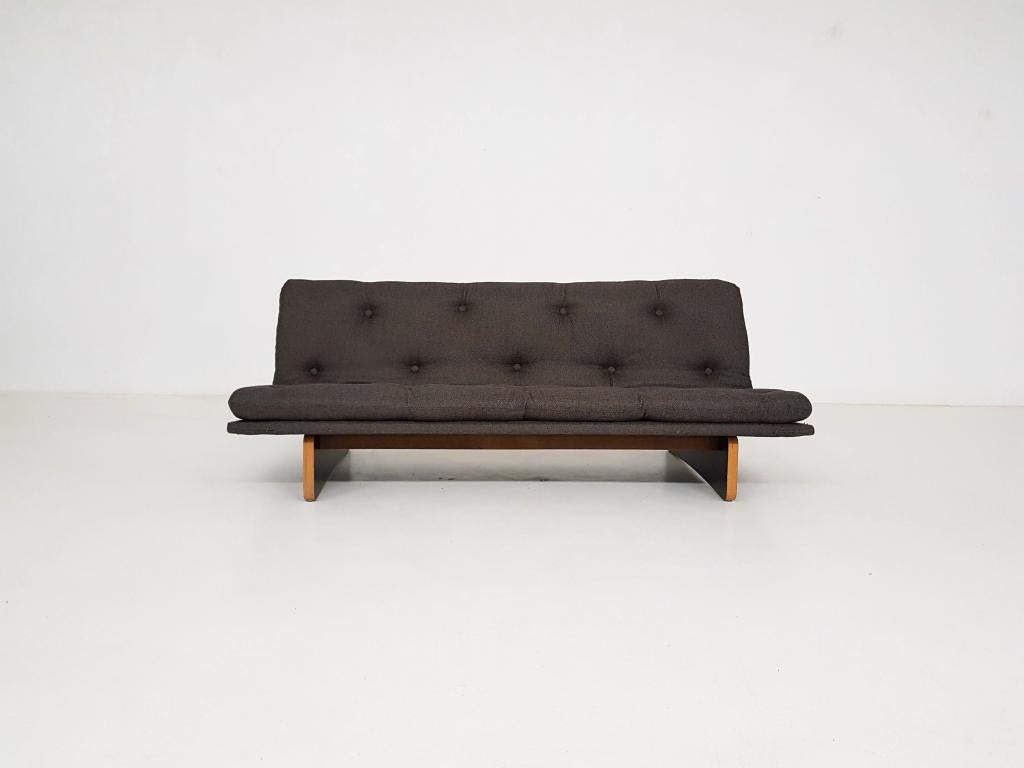 Design classic by Kho liang Ie for Artifort. Vintage model with the less common wooden base.

This sofa from the 1960s has new dark army green-grey upholstery and a wooden base in good condition.

Kho Liang Ie was born in China. In 1949 he moved to