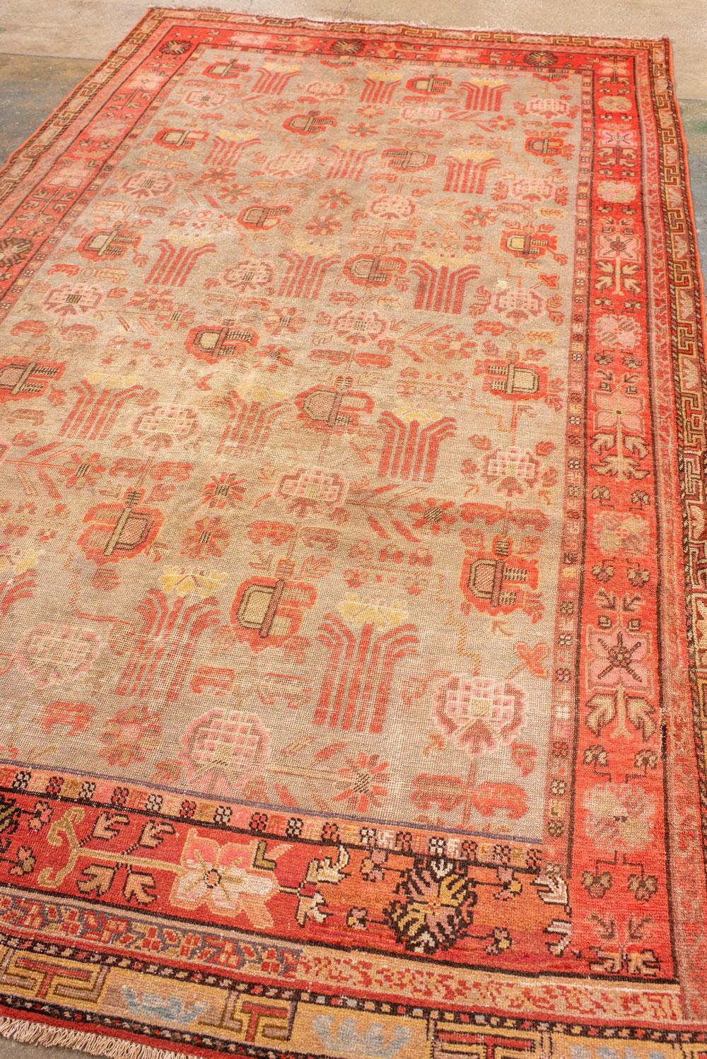 Une bordure chamois avec des octogrammes et des rosettes portant des fleurs, entoure le champ beige-tan avec des échelons de formes végétales géométriques et des ensembles de sept tiges.  Bordure extérieure étirée en T fret.

Taille du tapis
6' 0