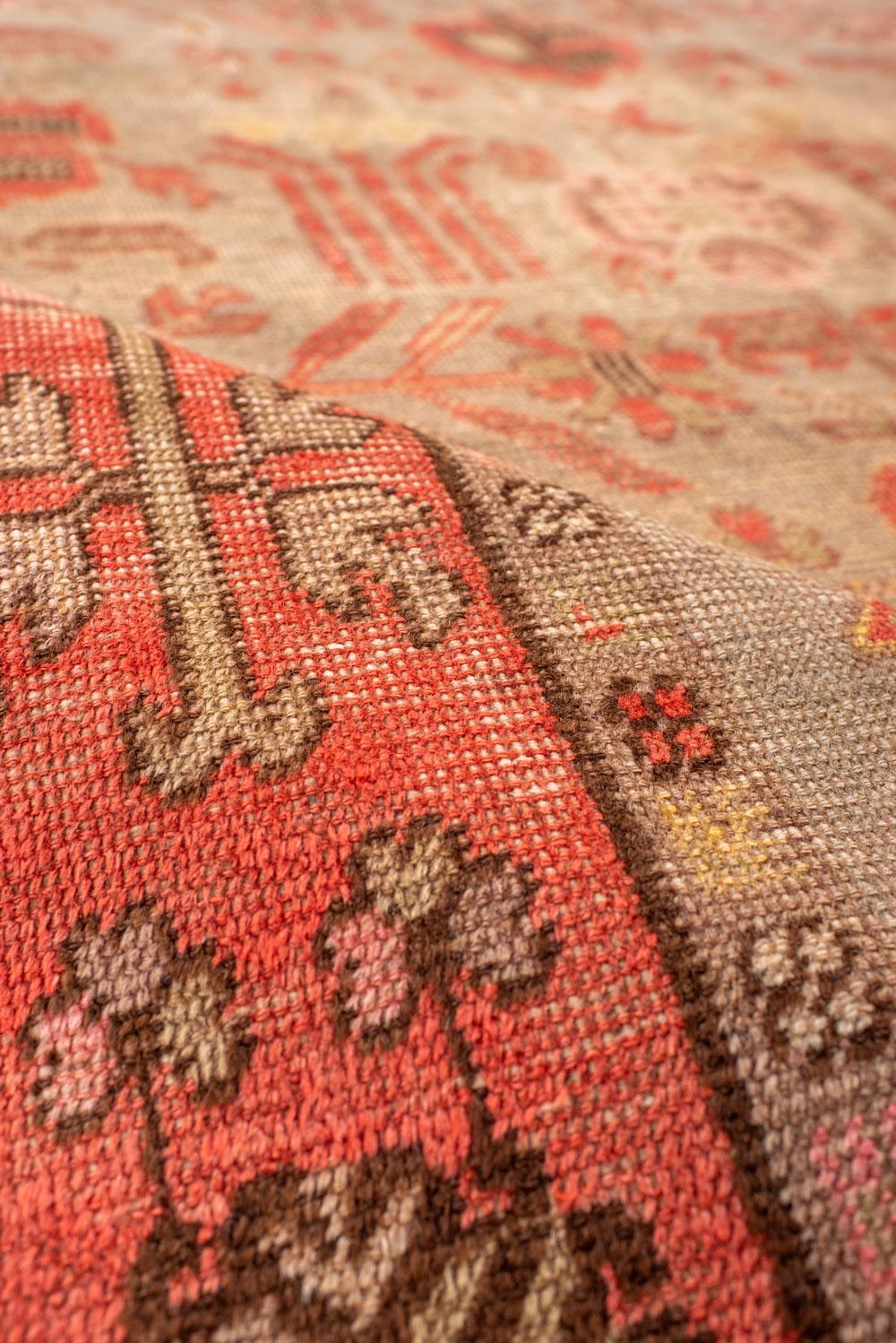 20ième siècle Tapis long Khotan avec un champ brun clair et un bordure corail en vente