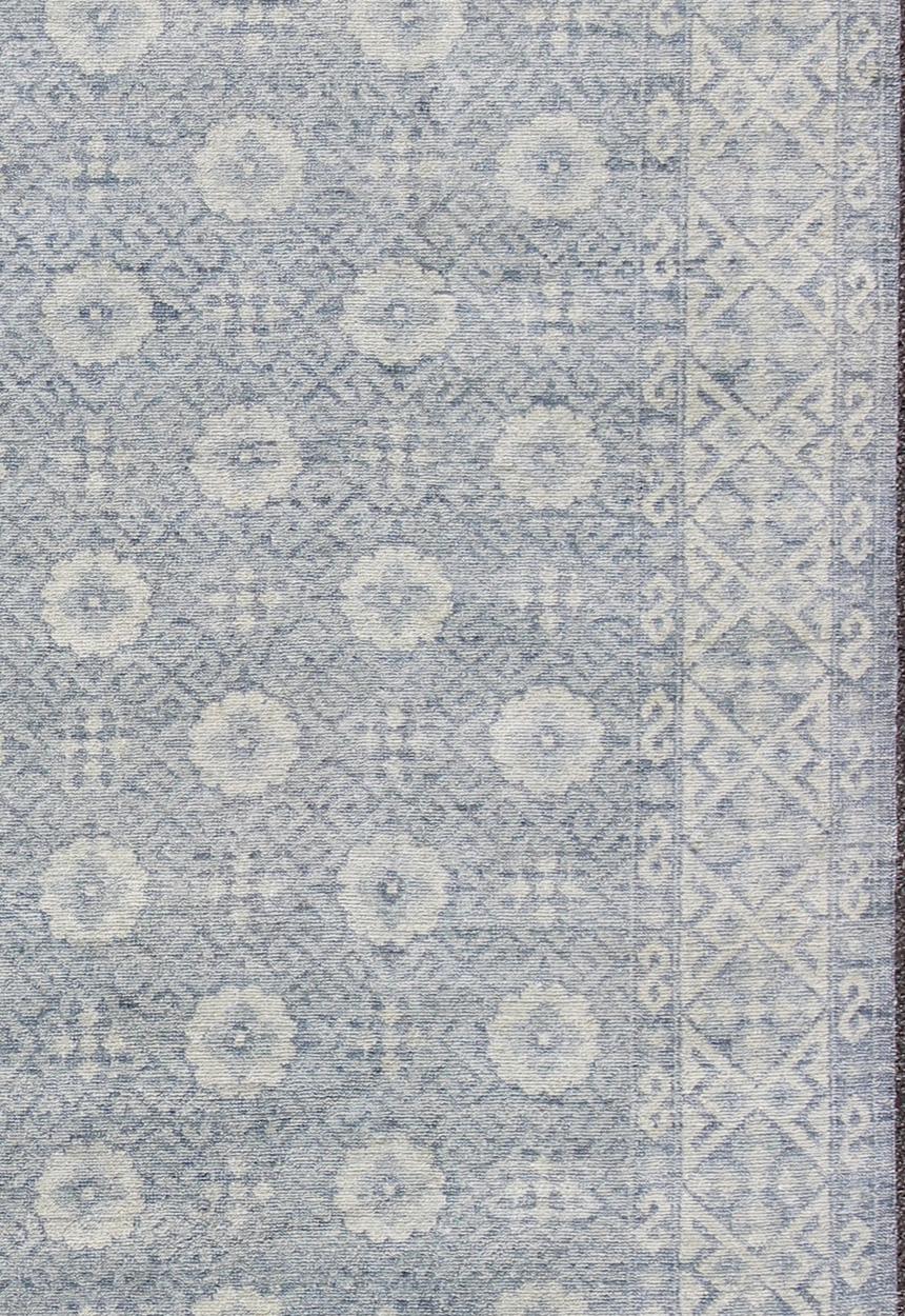 Keivan Woven Arts Khotan Rug in off White and Blue.
Measures: 9'2 x 12'1.
This superb hand knotted woolen Khotan by Keivan Woven Arts features an all over design with geometric shapes and patterning enclosed within a complementary border. The rug is