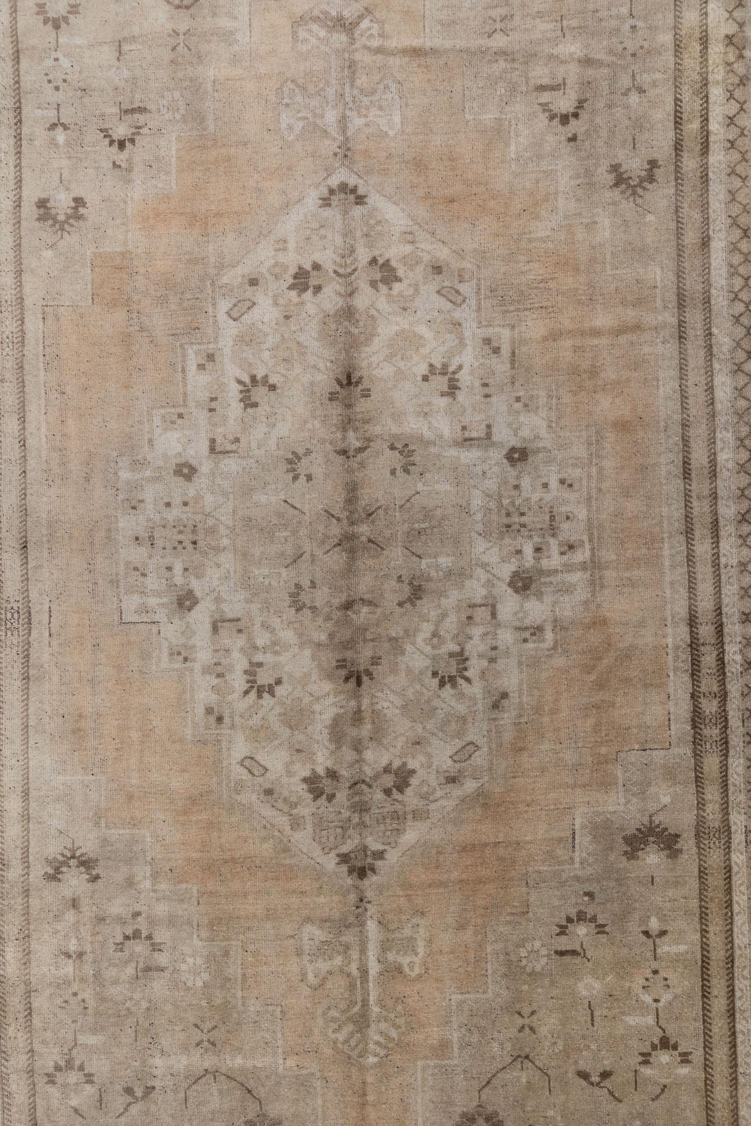 Un bellissimo tappeto antico Turkestan Khotan con un campo marrone e pesca e accenti marroni nel disegno del medaglione centrale.