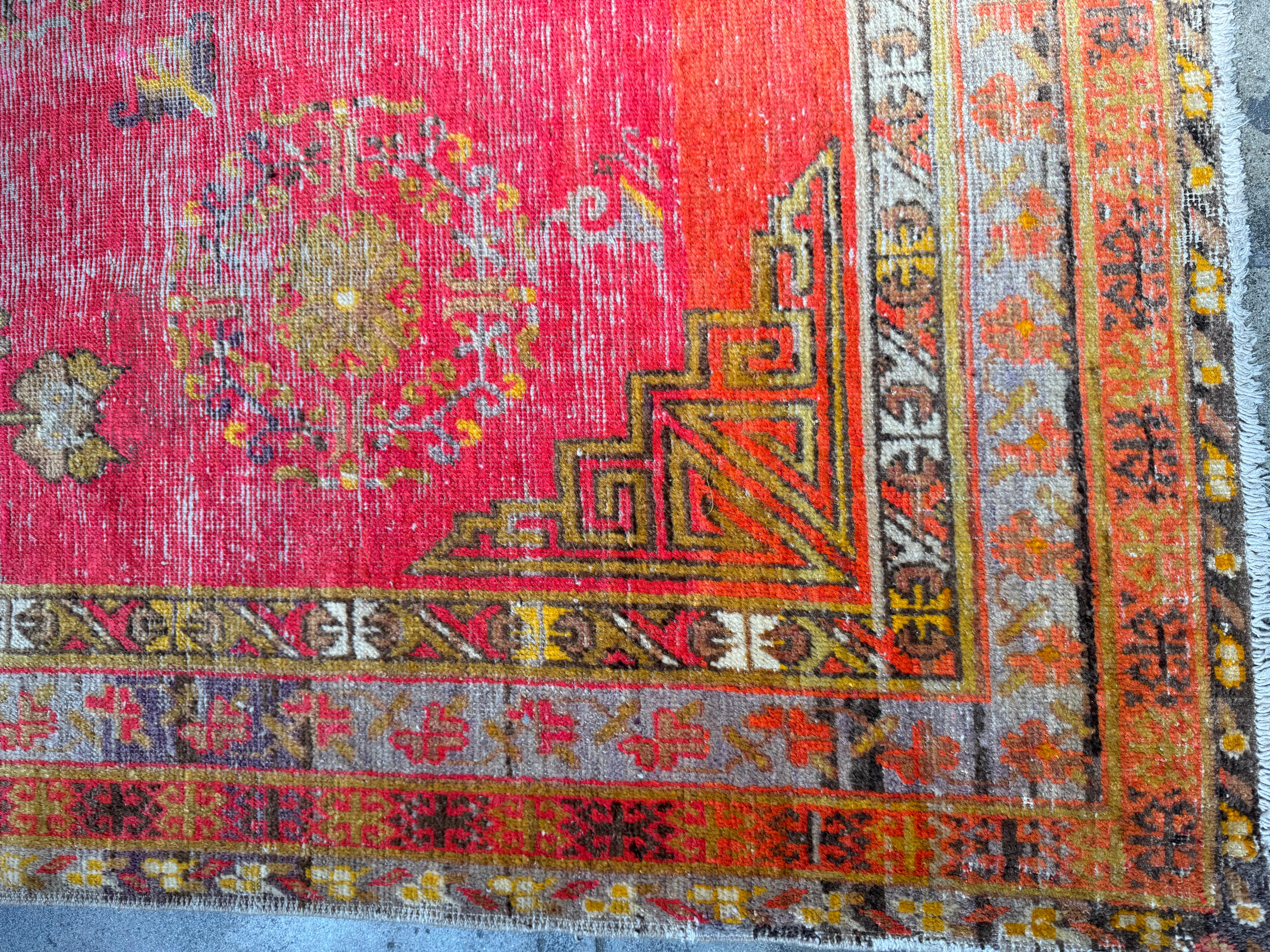 Verwandeln Sie Ihren Raum mit diesem exquisiten Vintage-Teppich aus Khotan-Samarkand, einem wahren Schatz aus der Zeit der Seidenstraße, der mit unvergleichlicher Handwerkskunst handgewebt wurde. Sein leuchtend rotes Feld, das mit komplizierten