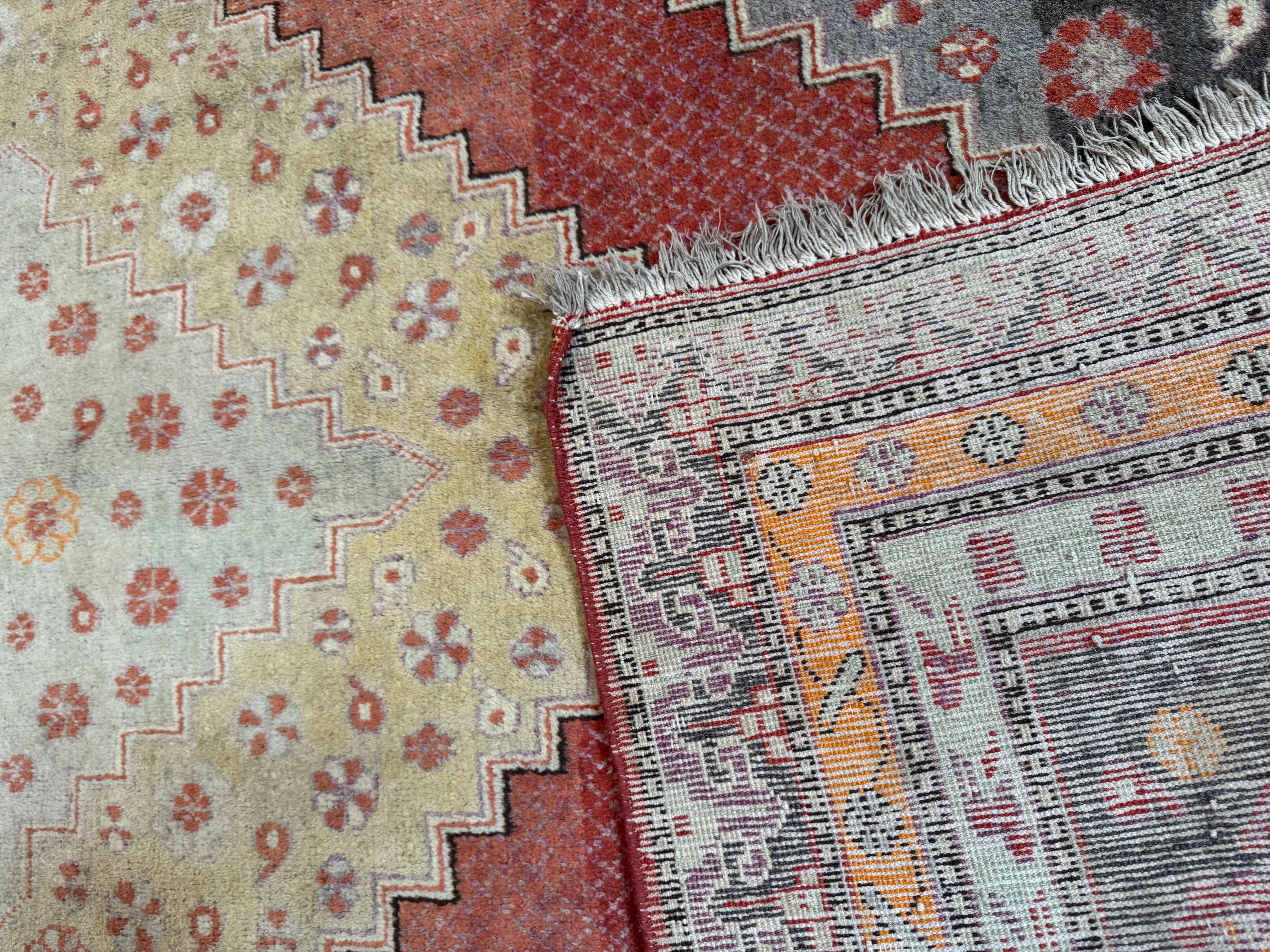 Transformez votre espace avec cet exquis tapis vintage Khotan Samarkand, un chef-d'œuvre de l'artisanat d'Asie centrale qui mêle des motifs floraux complexes à des motifs géométriques audacieux. Tissé à la main avec de la laine de haute qualité, ce