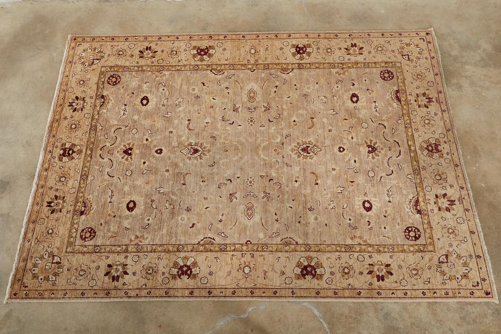 Distinctive beige field rug or carpet made in the style of East Turkestan Khotan with dense hand knotted wool. Decorated with stylized flowers and vines in muted greens and browns. From an estate in San Francisco, CA.