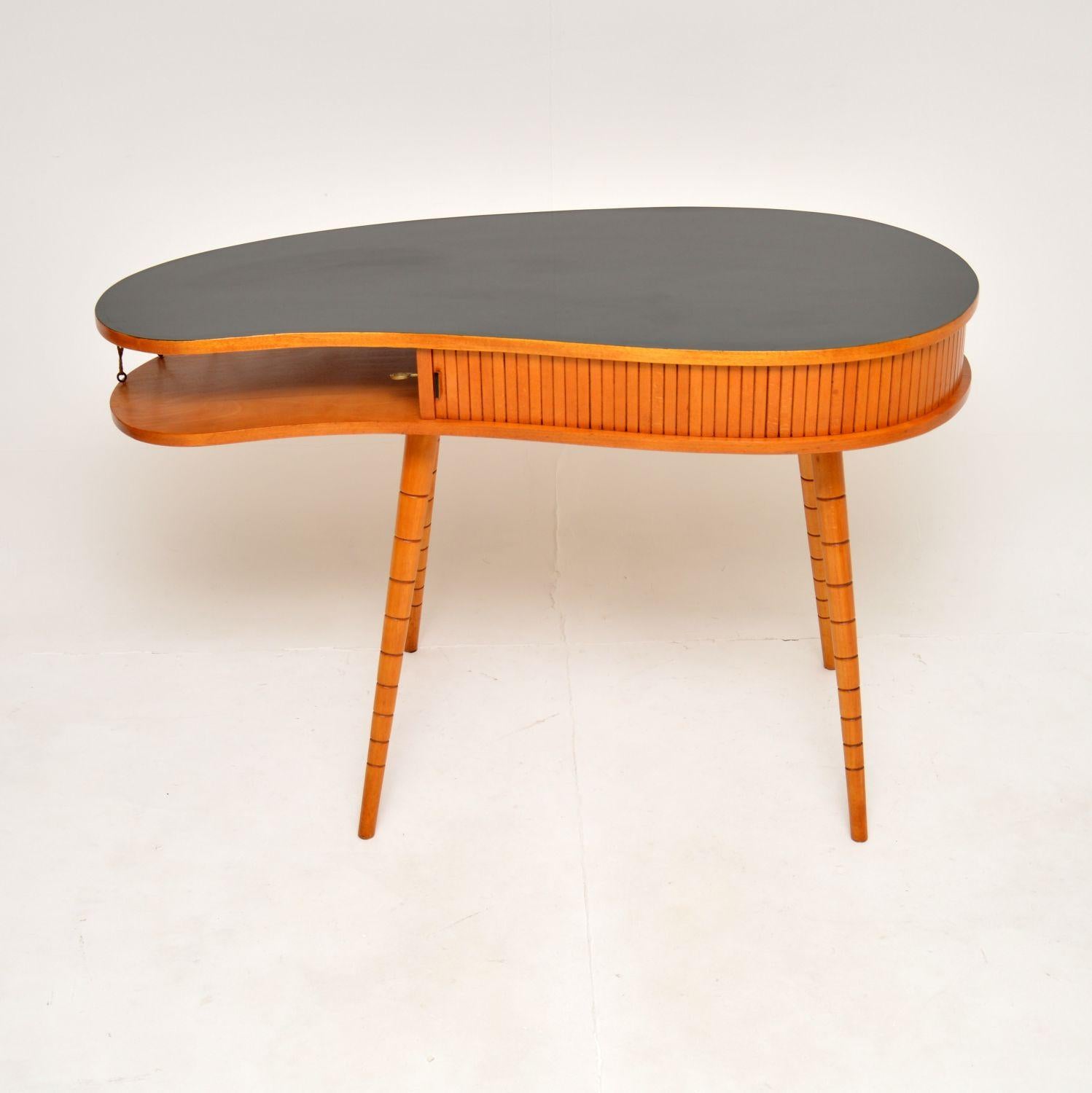 An outstanding vintage kidney shaped desk attributed to Eduard Ludvig, the well known German architect. This was made in Germany, it dates from the 1950’s.

It has a fantastic and very stylish design, the black laminated top has a kidney shape and