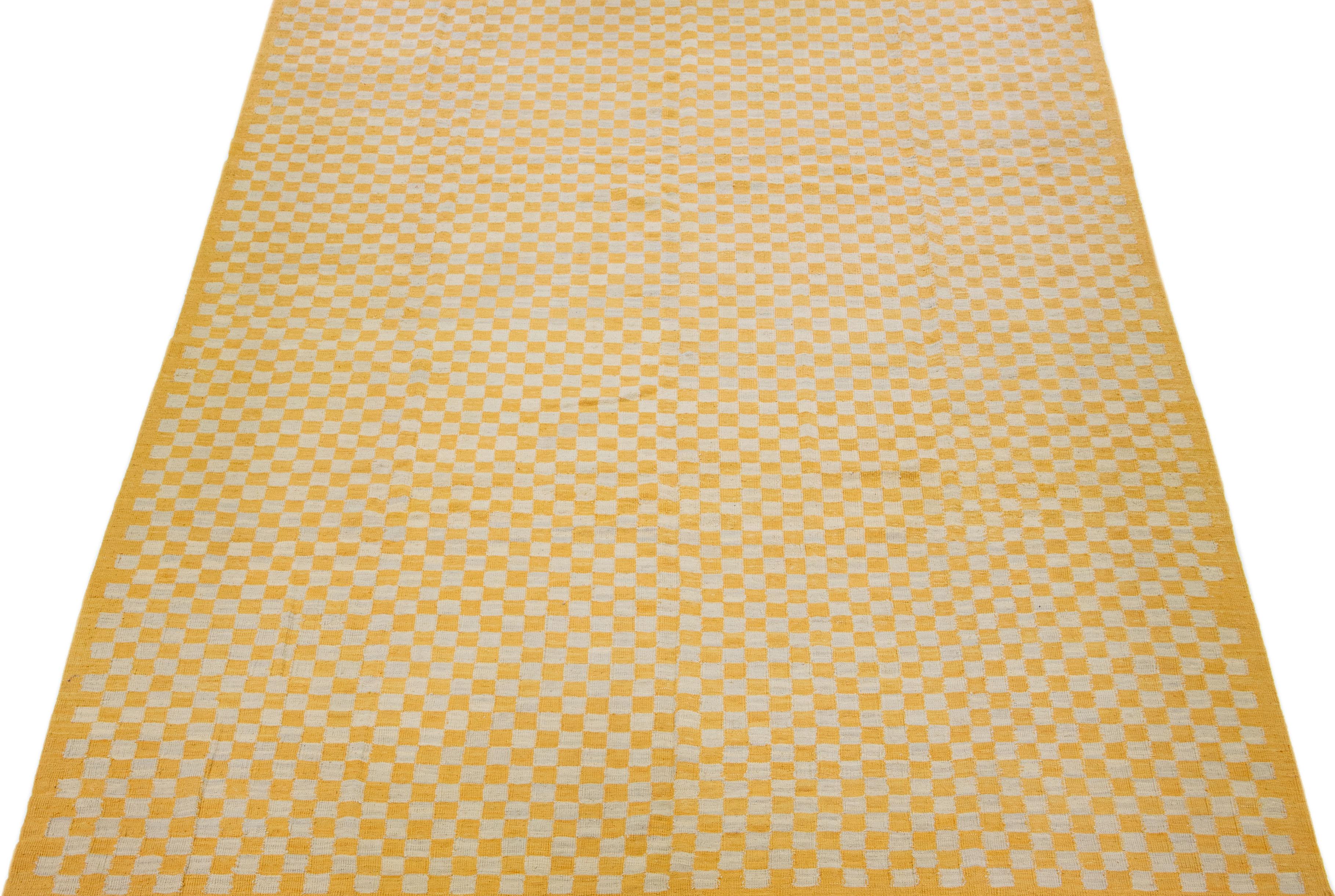 Beautiful Mid-Century vintage Kilim flatweave wool rug with peach and orange color field features a gorgeous allover checker motif. 

This rug measures: 10'7