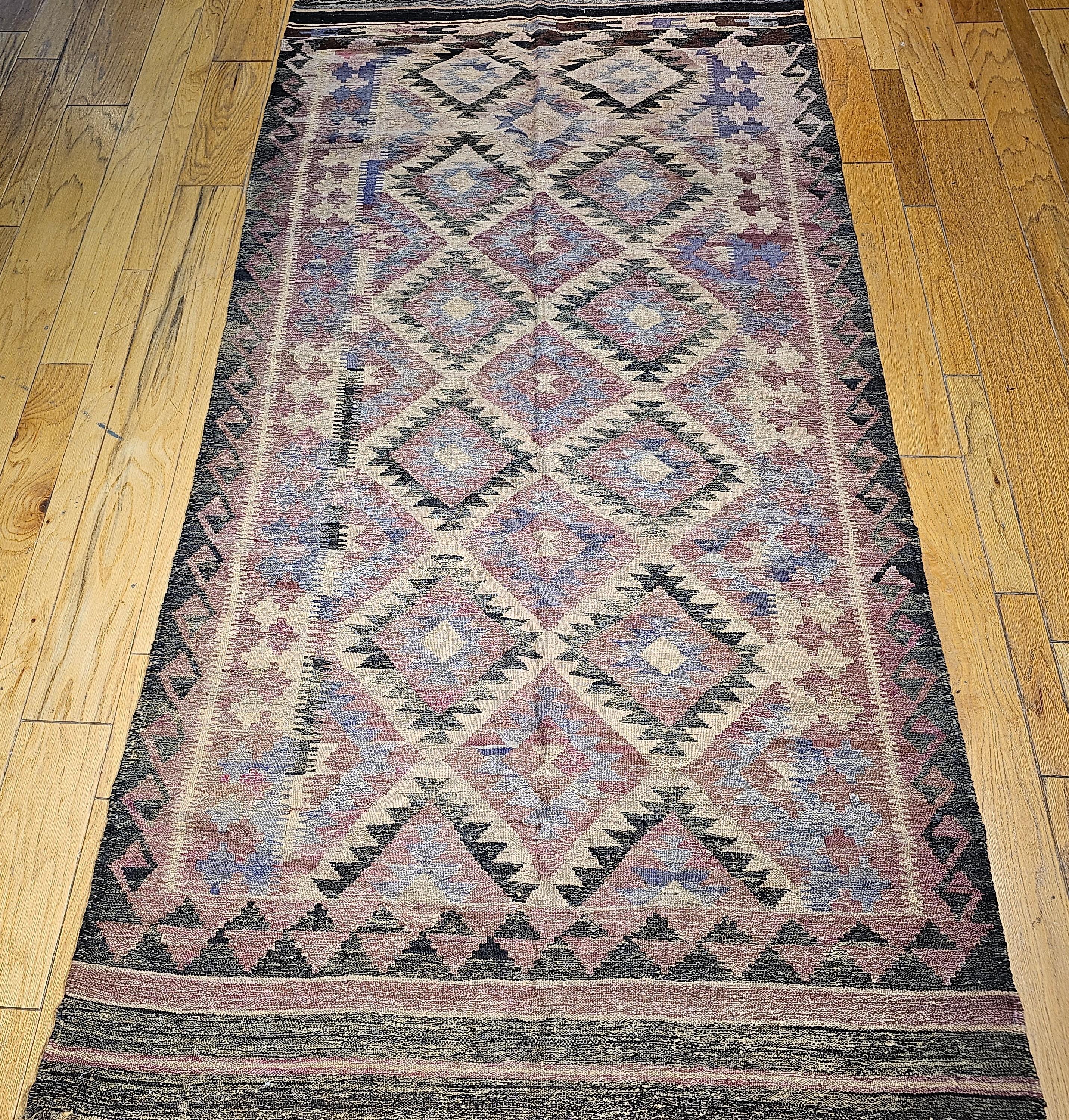  Vintage Turkish Kilim in geometric pattern  in beautiful soft earth tone colors.  The colors in this Turkish Kilim include abrash (variations caused by the use of natural dyes) lavender, cream, gray, black, beige, brown, and pale brick red