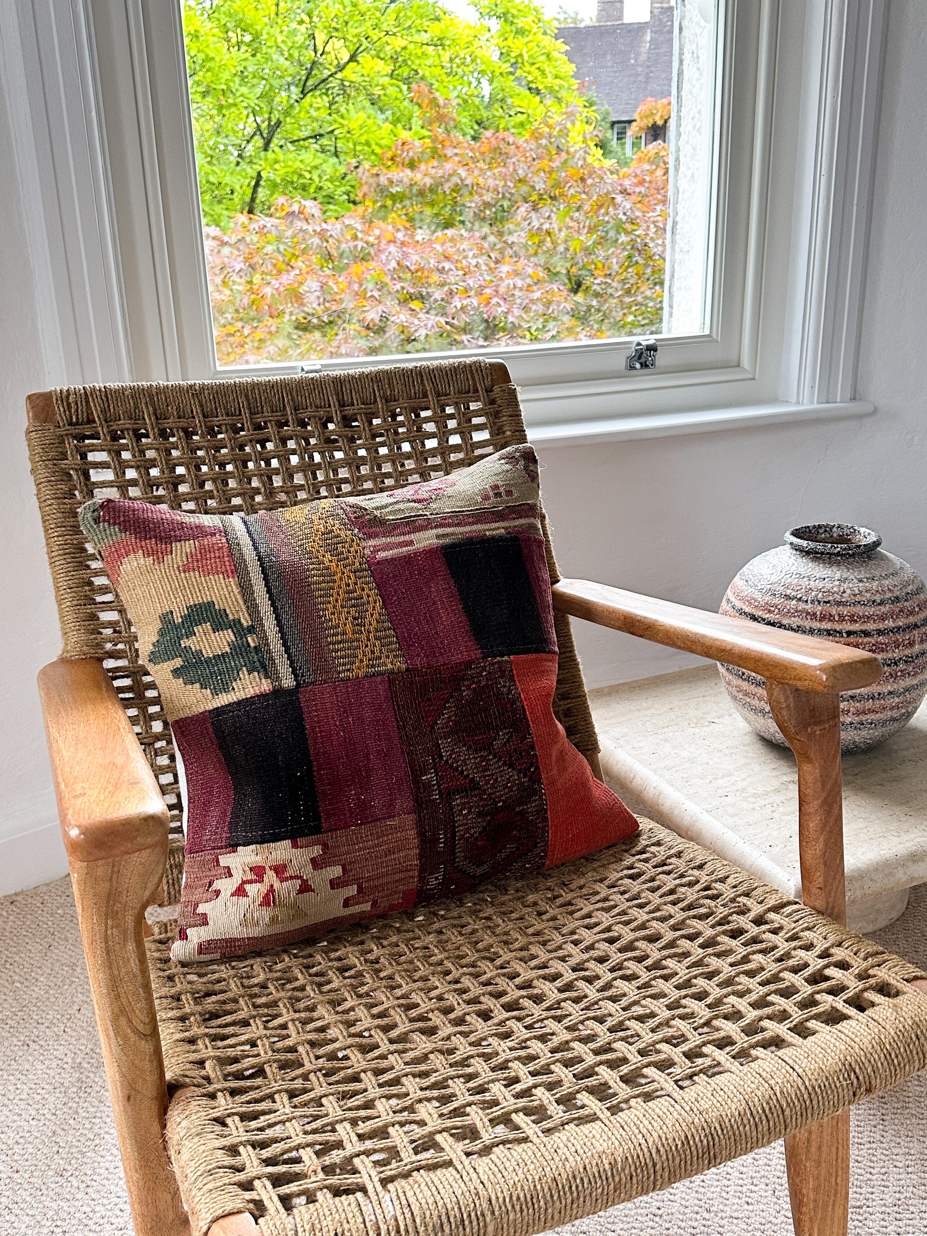 Luxury pillow created from an exquisite piece of vintage kilim rug combined with Irish Linen by Irish designer Katie Larmour. Unique and one-of-a-kind. 

In rich, warm, dramatic stripes of orangey rust red and soft black. 
The pieces of woollen rug