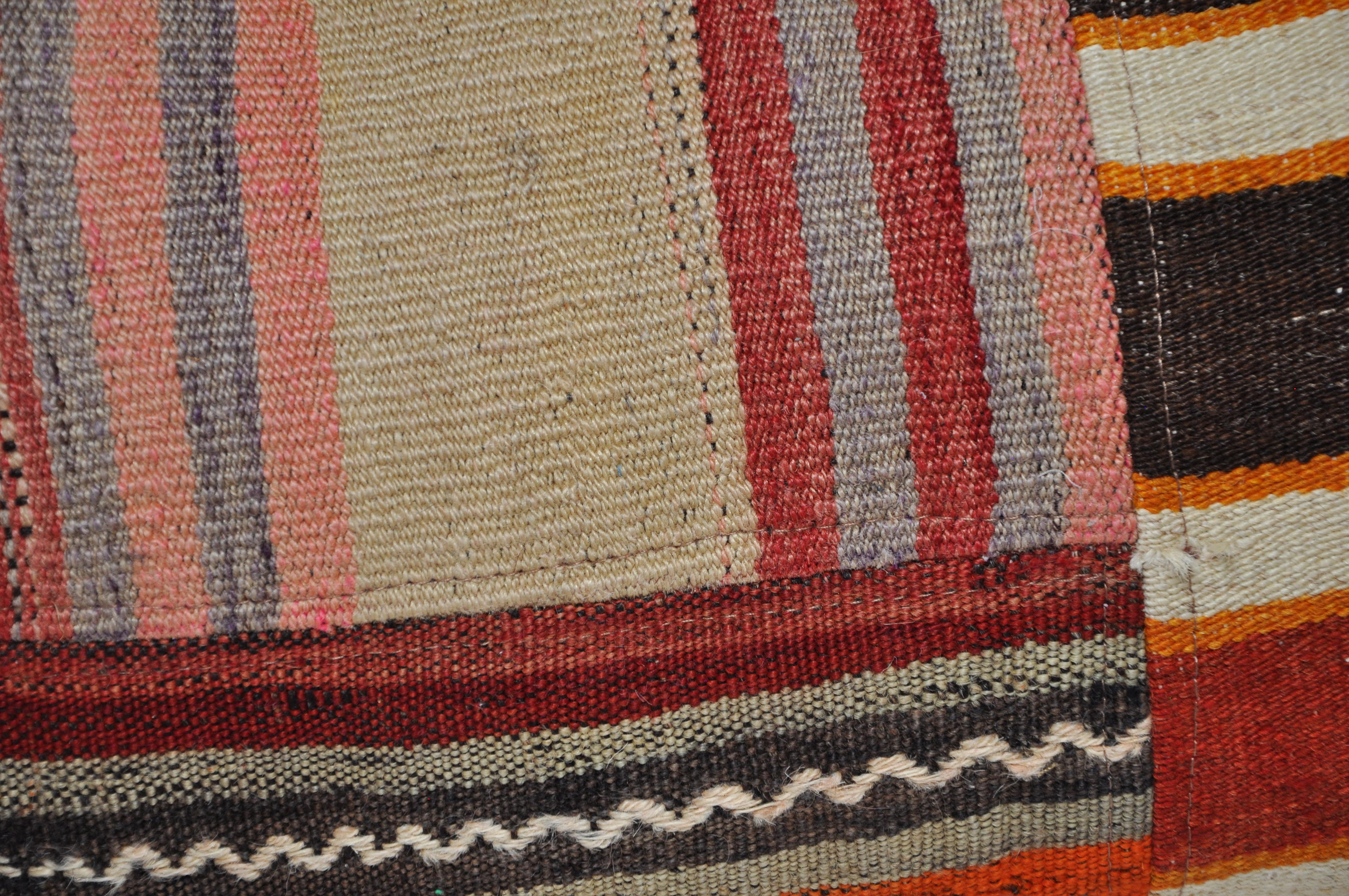Luxury pillow created from an exquisite piece of vintage kilim rug combined with Irish Linen by Irish designer Katie Larmour. Unique and one-of-a-kind. 

In rich, warm, dramatic stripes of orangey rust red and soft black. 
The pieces of woollen rug
