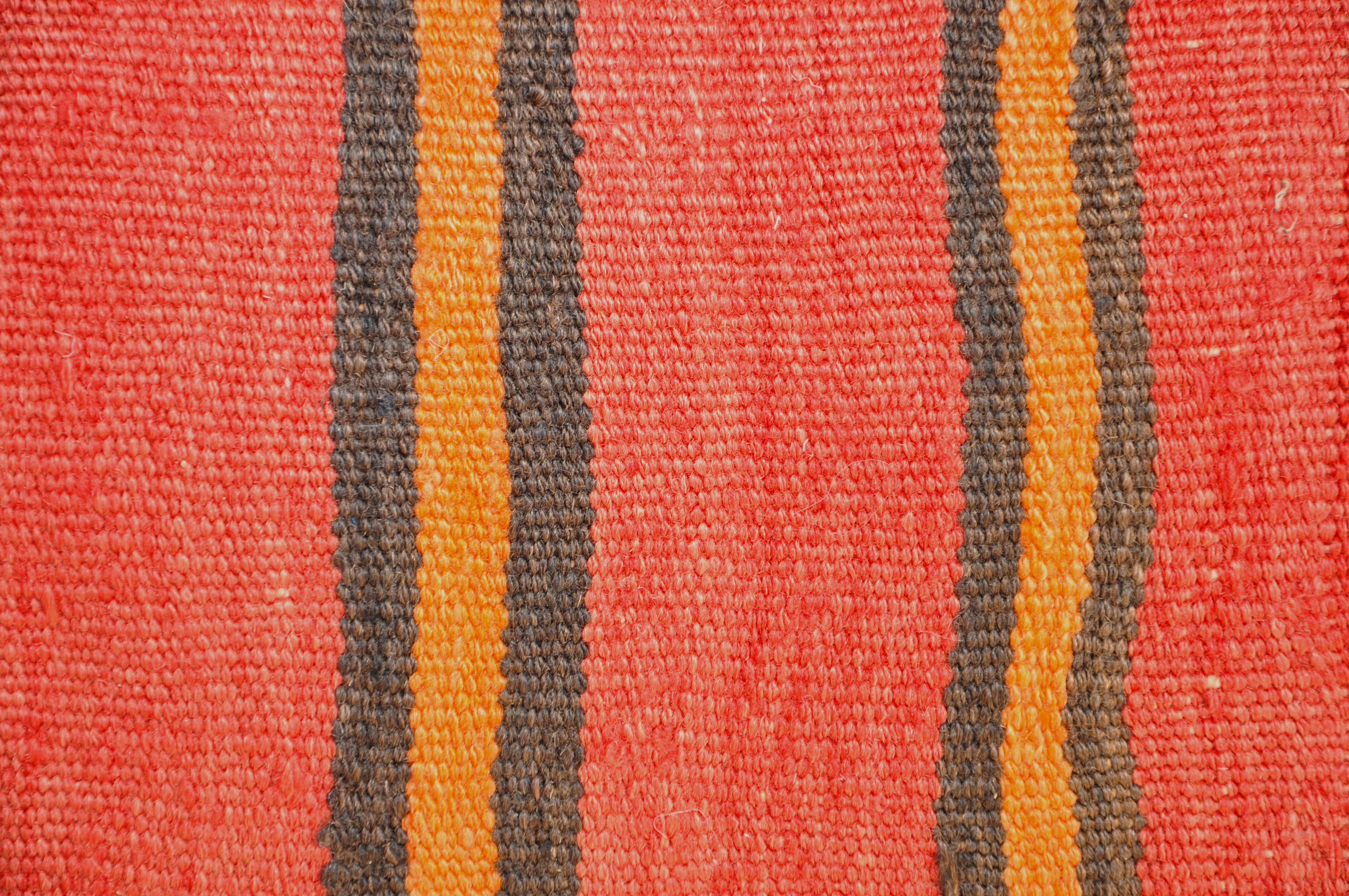 Luxury pillow created from an exquisite piece of vintage kilim rug combined with Irish Linen by Irish designer Katie Larmour. Unique and one-of-a-kind. 

In rich, warm, dramatic stripes of orangey rust red and soft black. 

Each cushion is