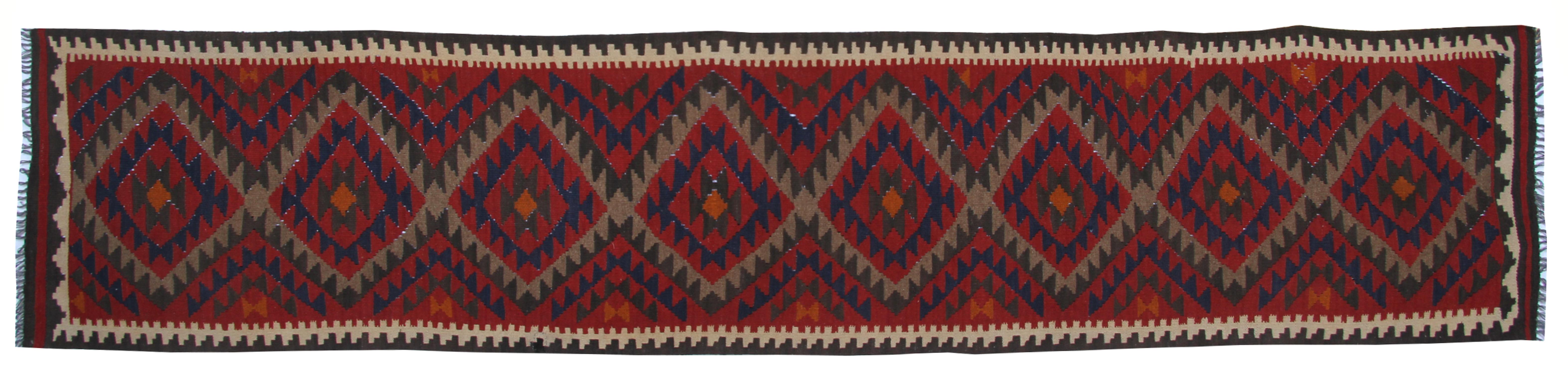 This handwoven vintage Kilim runner rug features a repeat geometric pattern. This piece features a traditional colour palette of predominantly red, blue, beige, and brown. Designed with a traditional Afghan pattern. Woven with the finest hand-spun