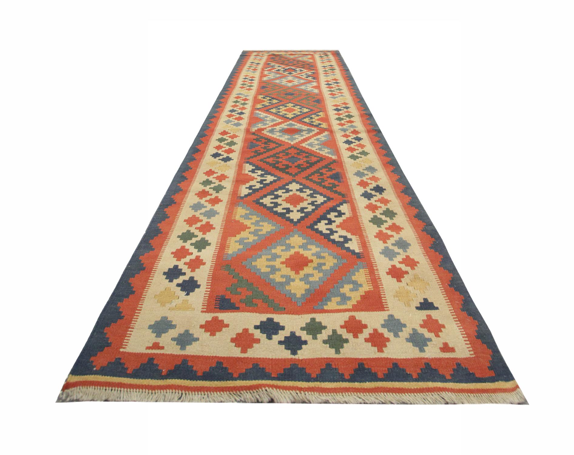 This beautiful Kilim rug has been woven with subtle muted tones. Orange is the main colour in this geometric rug. Zig-zags and diamond patterns cover this runner beautifully designed and handwoven. This rug is sure to uplift any interior instantly.