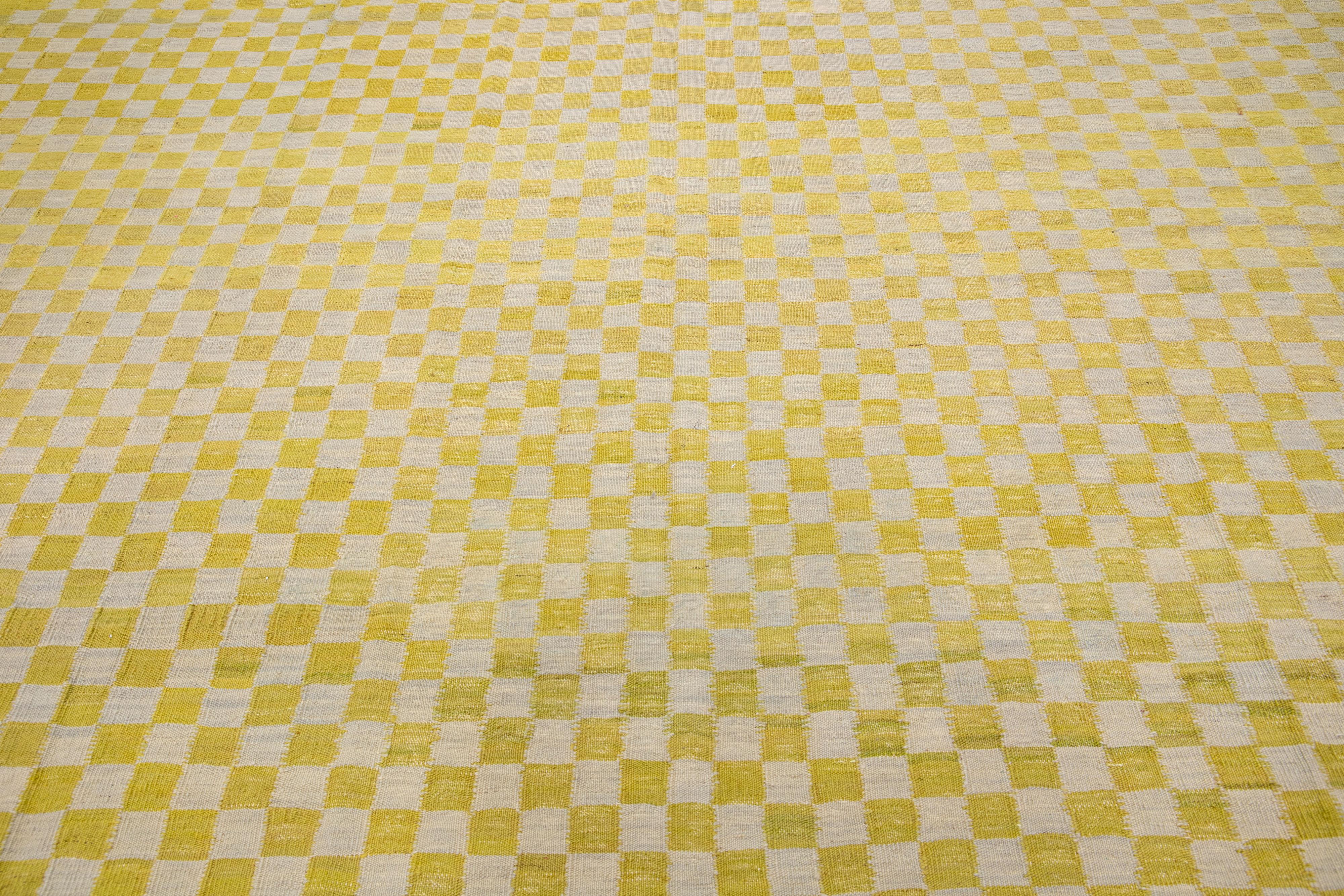 Beautiful mid-century vintage Kilim flatweave wool rug with beige and yellow color field features a gorgeous allover checker motif. 

This rug measures: 10'6