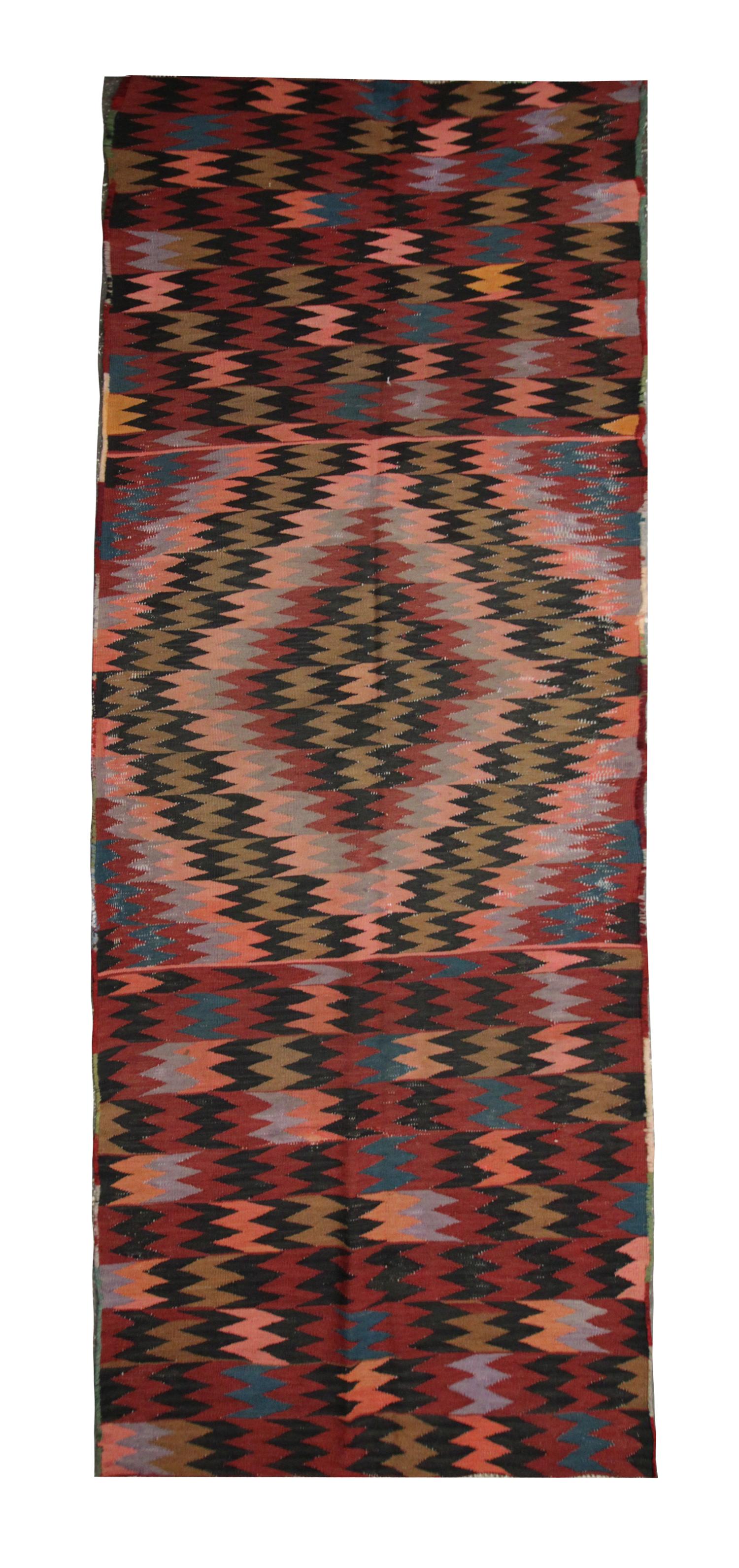This fine wool Kilim Runner is a modern flat-weave Kilim rug constructed in the early 2000s. The design features a repeat geometric design woven with a vibrant colour palette including rust, beige and brown that make up the repeat geometric design.