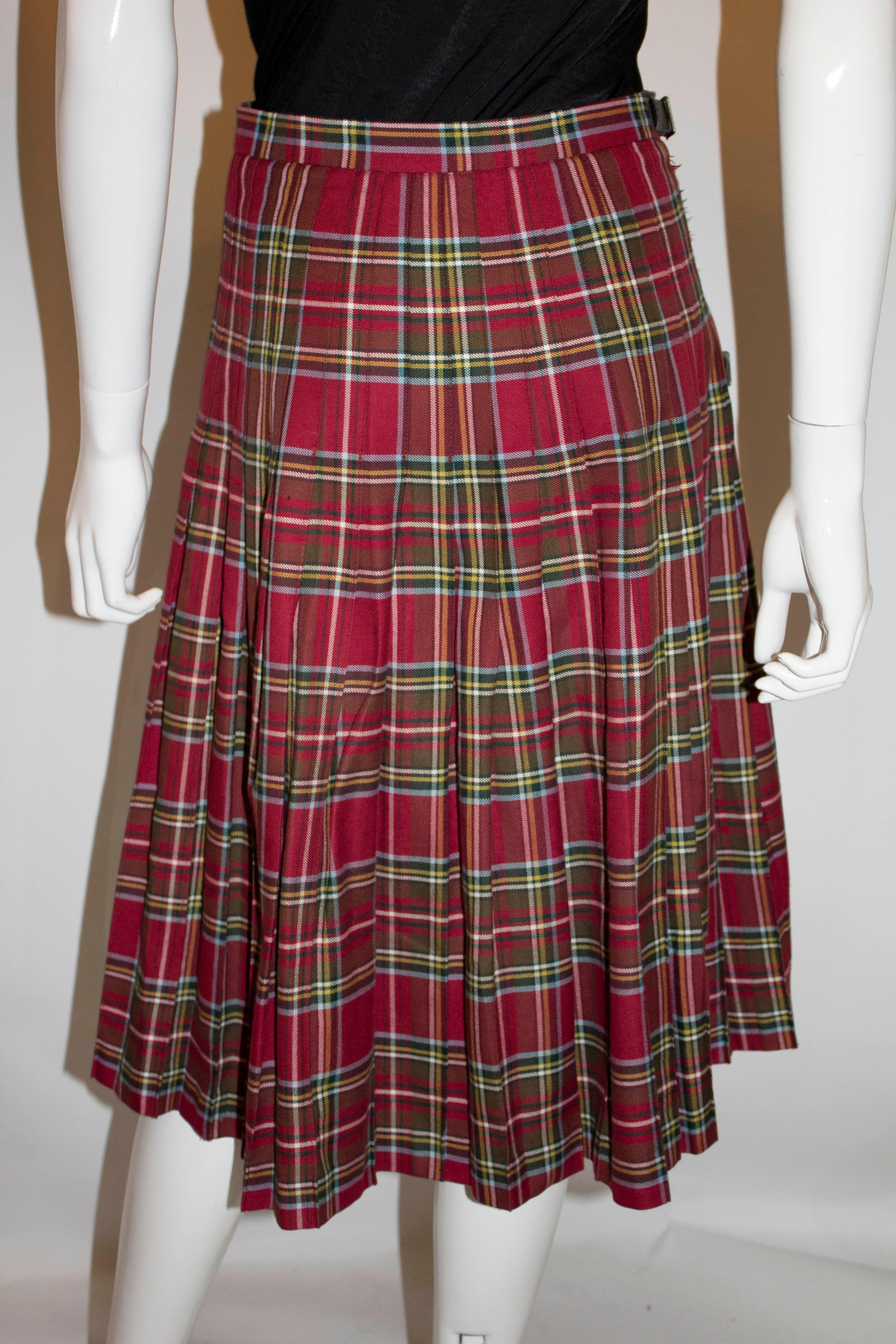 A lovely vintage kilt for Fall by Strathmore of Forfar Scotland . The kilt has a red background with a yellow , green and pale blue stripe.  It has sewn down pleats from the waist band and wraps over. It is unlined. Measurements Waist 28'', length