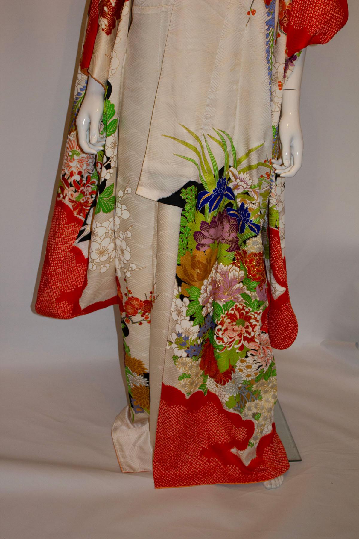 Ein aufsehenerregender Vintage-Kimono mit einem mehrfarbigen Blumenkorbmuster. Der Kimono ist am Saum orangefarben und hat goldene Details um die Blütenblätter. Abmessungen:
Büste bis zu 48'', Länge 62''