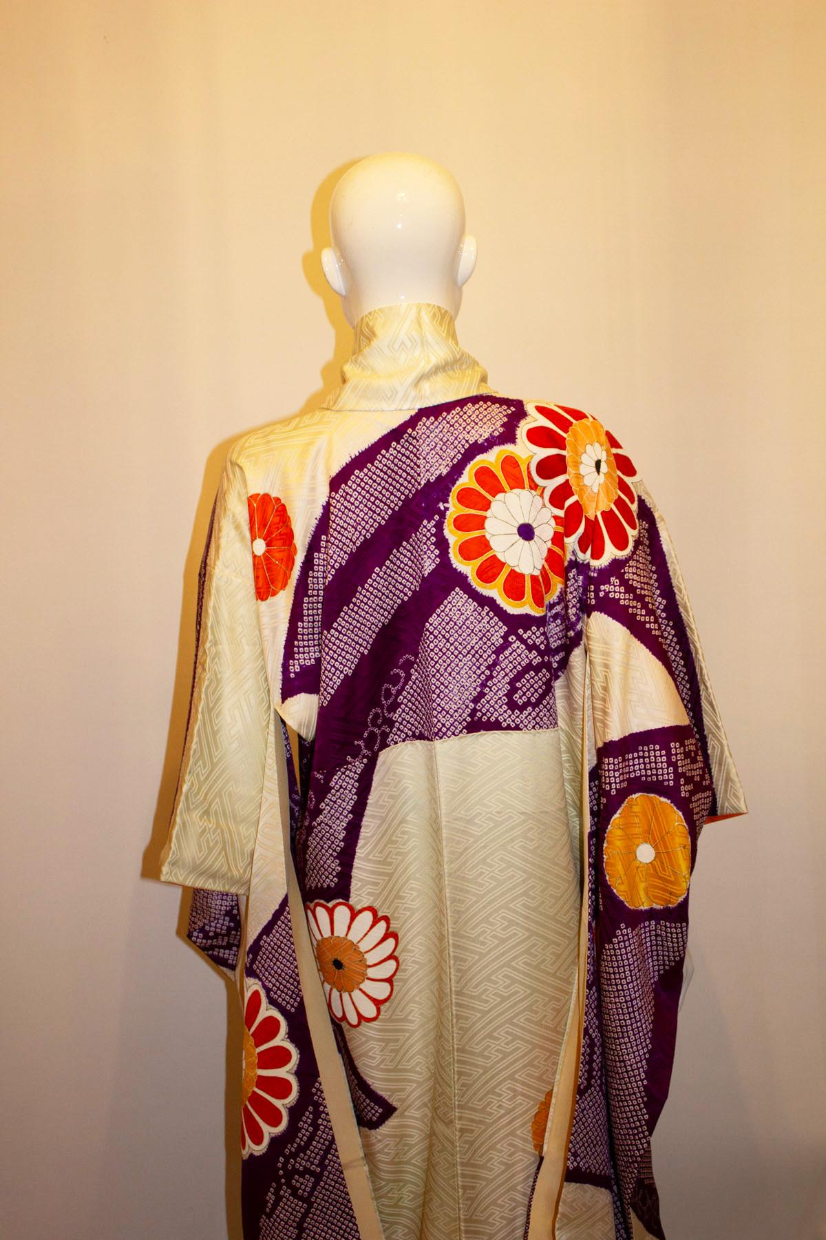 A stunning vintage kimono with orange and purple flower detail. The kimono has an orange band at the base, and gold detail around the flower petals.
Measurements: Bust up to 48'', length 62''