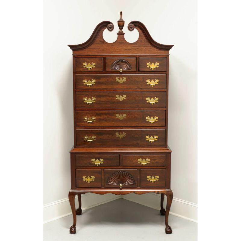 A Chippendale style highboy chest by Kindel Furniture, of Grand Rapids, Michigan, USA. Solid Mahogany with brass hardware; complimented by pediment top with center finial, fan carvings, carved knees, curved legs with ball and claw feet. Features
