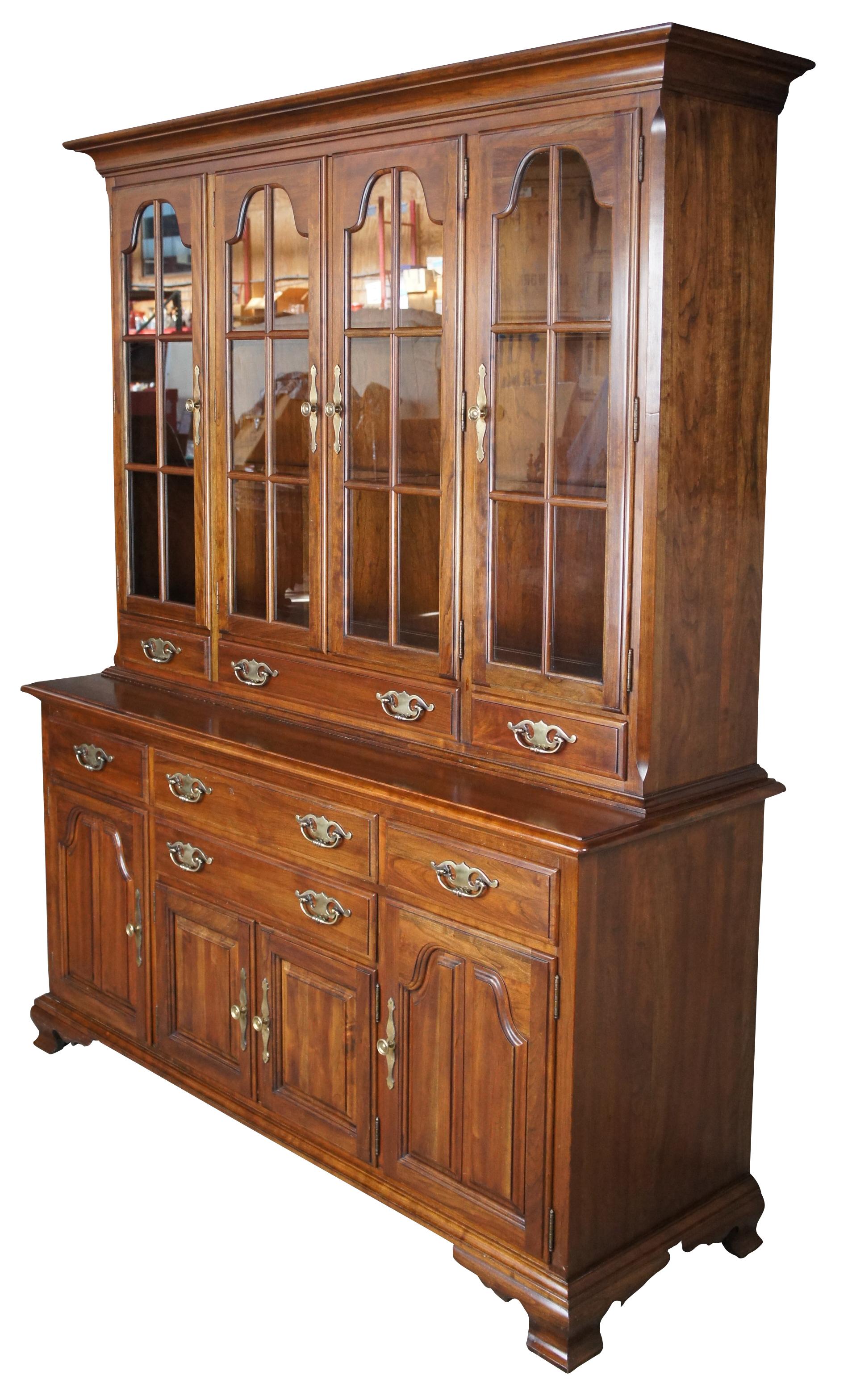 Circa 1970s Kling Colonial Solid Cherry China cabinet. Features a stepback hutch with arched and fretted glass doors over 3 quaint drawers. Opens to three shelves and glass inserts. Bottom buffet portion has four dovetailed drawers over three
