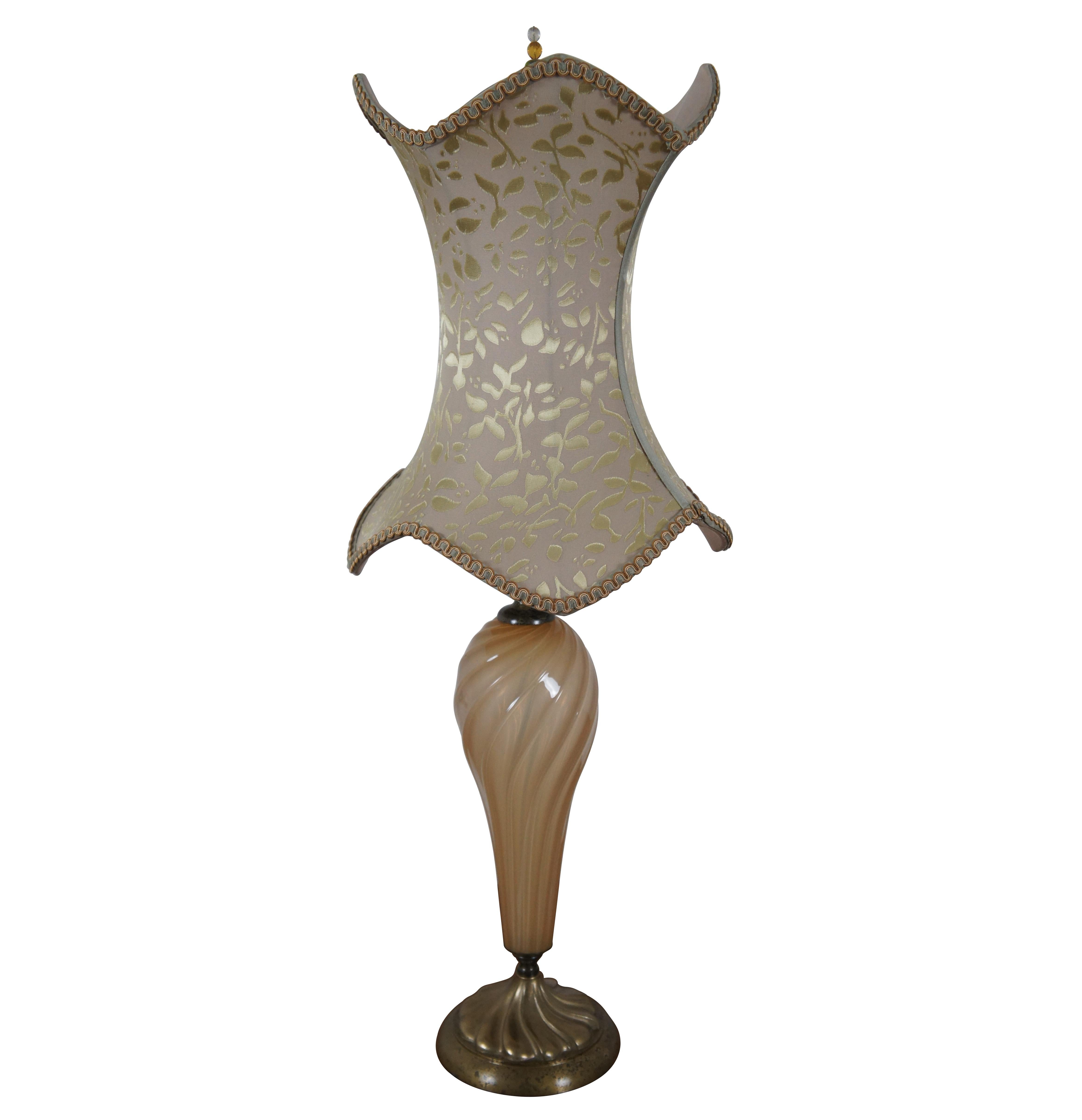 Melissa is a striking mixed media table lamp by Kinzig Design with a gold colored, swirling blown glass body set onto a brass base with copper coiled around the neck of the lamp. Its sexy, tall corset shaped, round, burnt velvet shade is covered