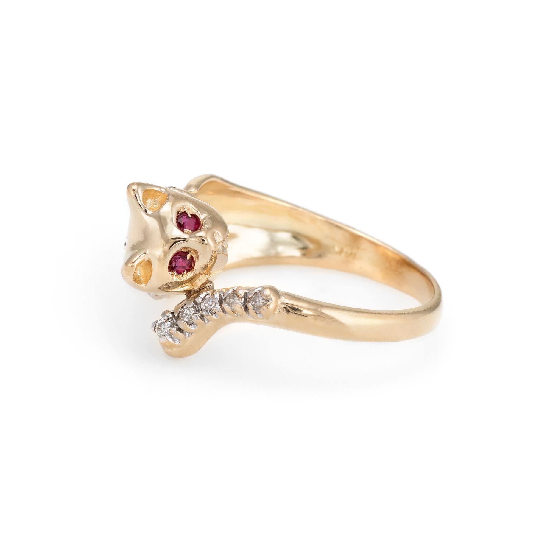 Finely detailed vintage kitty cat ring, crafted in 14 karat yellow gold. 

10 round brilliant cut diamonds total an estimated 0.05 carats (estimated at H-I color and SI2-I1 clarity). The eyes are set with two estimated 0.01 carat rubies.  

The