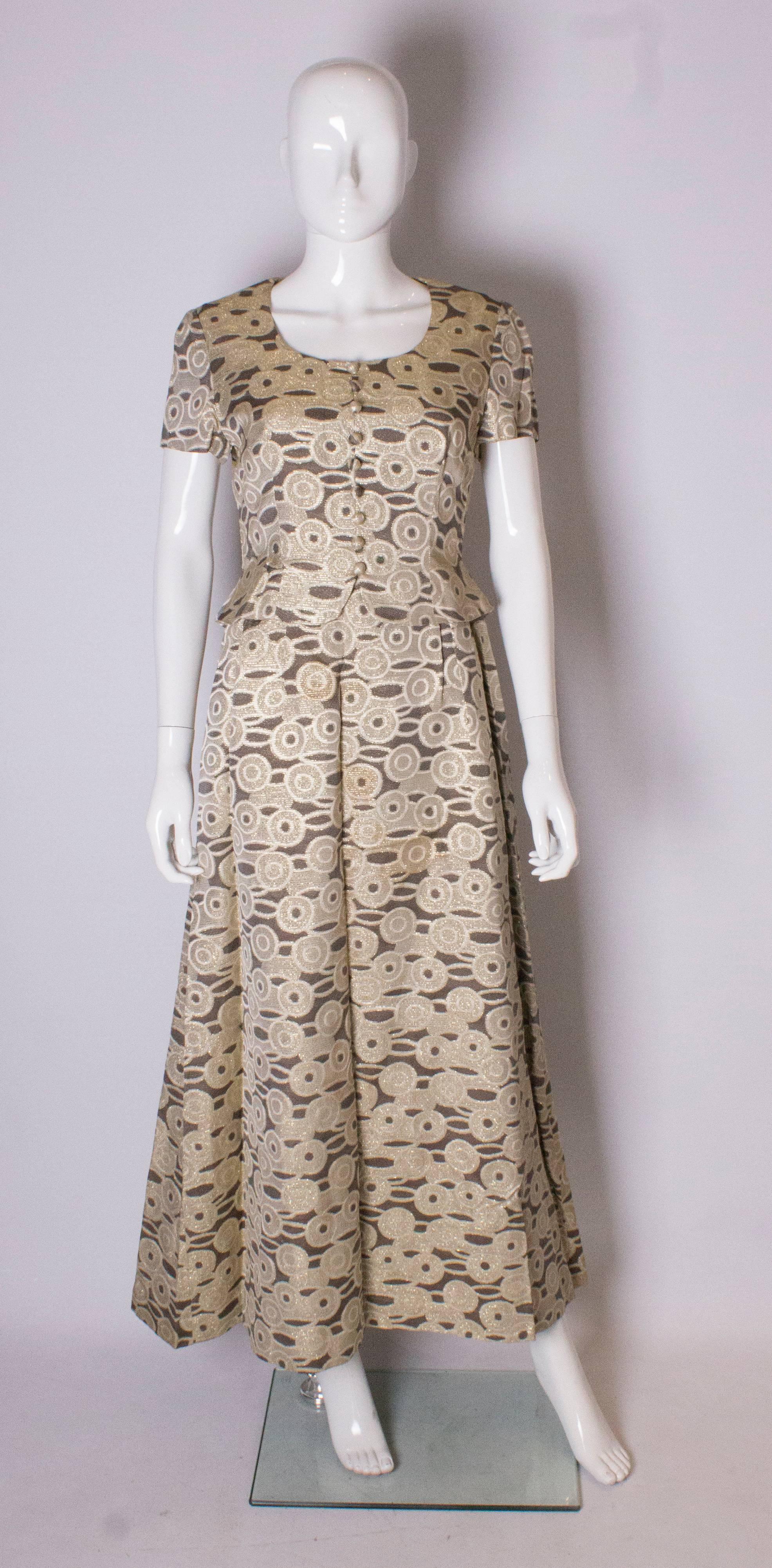 A great  vintage gown by Kitty Copeland. The gown is in a chocolate brown and gold fabric with button front and short sleeves.