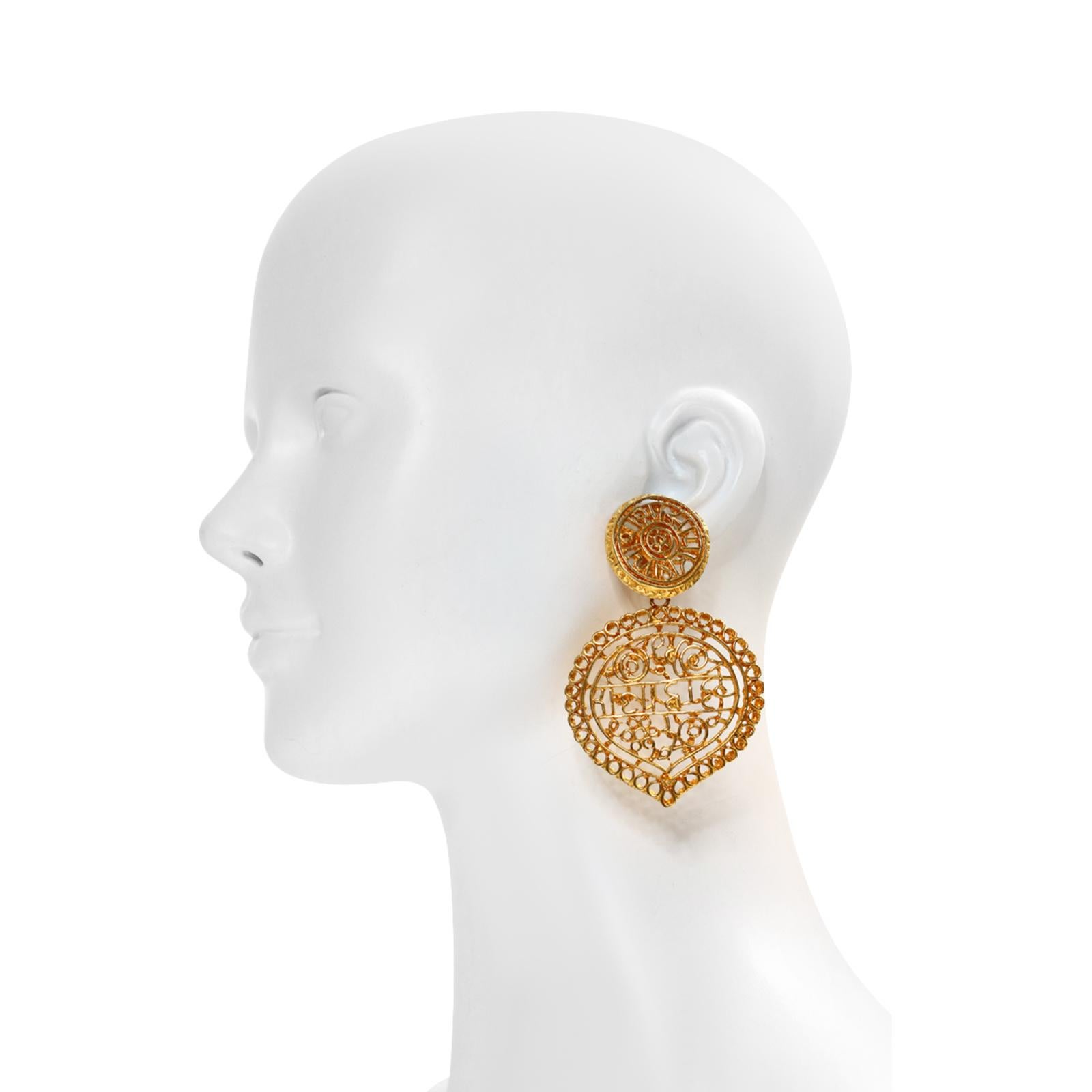 Vintage KJL Gold Tone Dangling Earrings. Large dangling front facing earrings with gold swirly patterns that appear to have some script writing. Tear dropped that hang from a round shape.  KJL made and still makes some great jewelry. Some of the