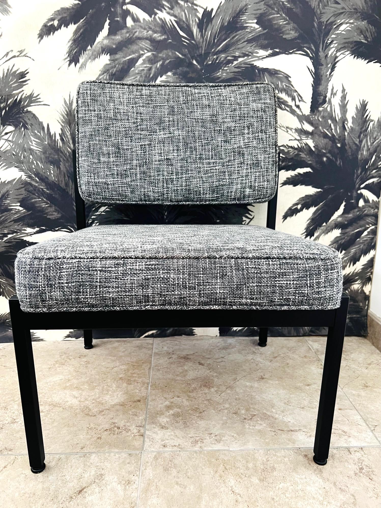 Mid-Century Modern chair with minimalist industrial design. Fine example of utilitarian furniture, great as an office chair or as an easy chair. Satin black enameled metal frame is complimented by a black and ivory woven tweed upholstery by Rogers &