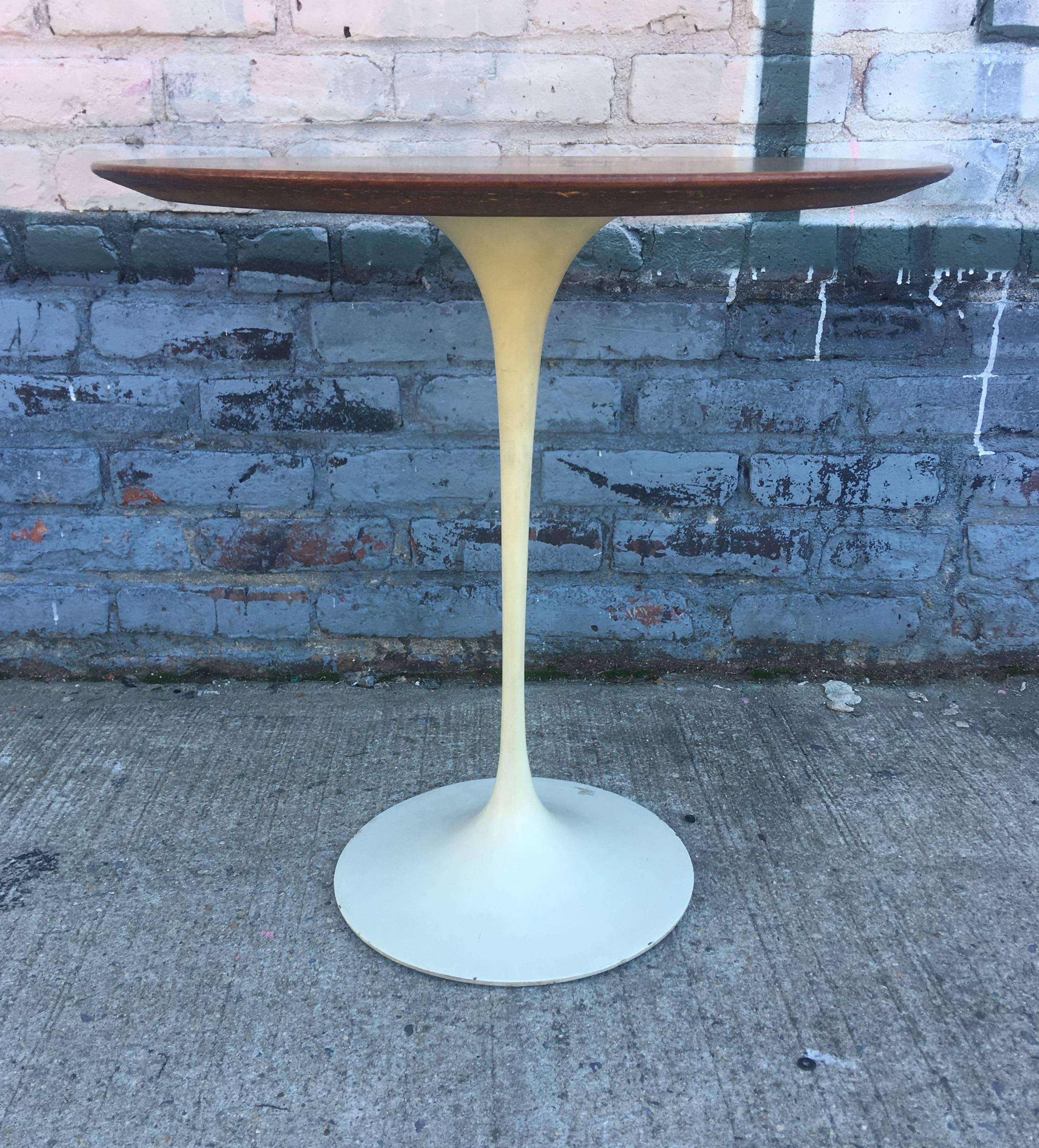 Vintage tulip side table with walnut top by Eero Saarinen for Knolll. Retains full earliest iteration bowtie label. In near perfect condition.