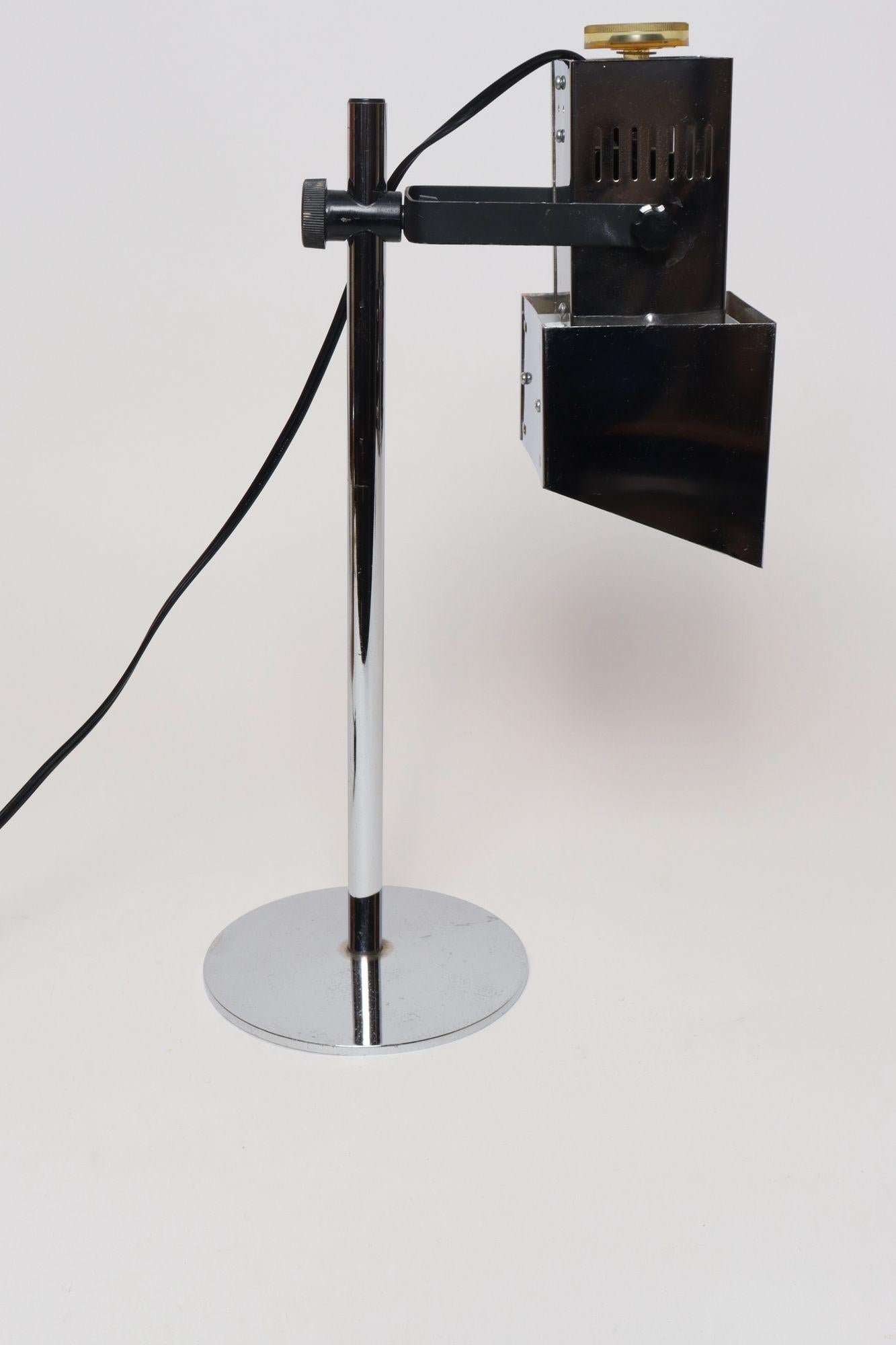 Vintage Koch & Lowy Chrome stage or spotlight-style task/table lamp (ca. 1970s, USA).
Featuring a geometric-form articulating shade with lucite on/off dial offering full height adjustability along a vertical stem measuring 15.5