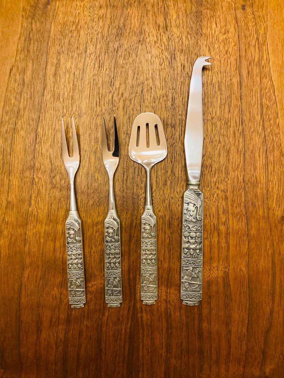 Beautiful set of 4, original-boxed, serving and entertaining flatware from Konge-Tinn. This “Royal Pewter” set includes the well cataloged pattern on utensils that describes events that took place in Norway hundreds of years ago. “Olav the Holy and