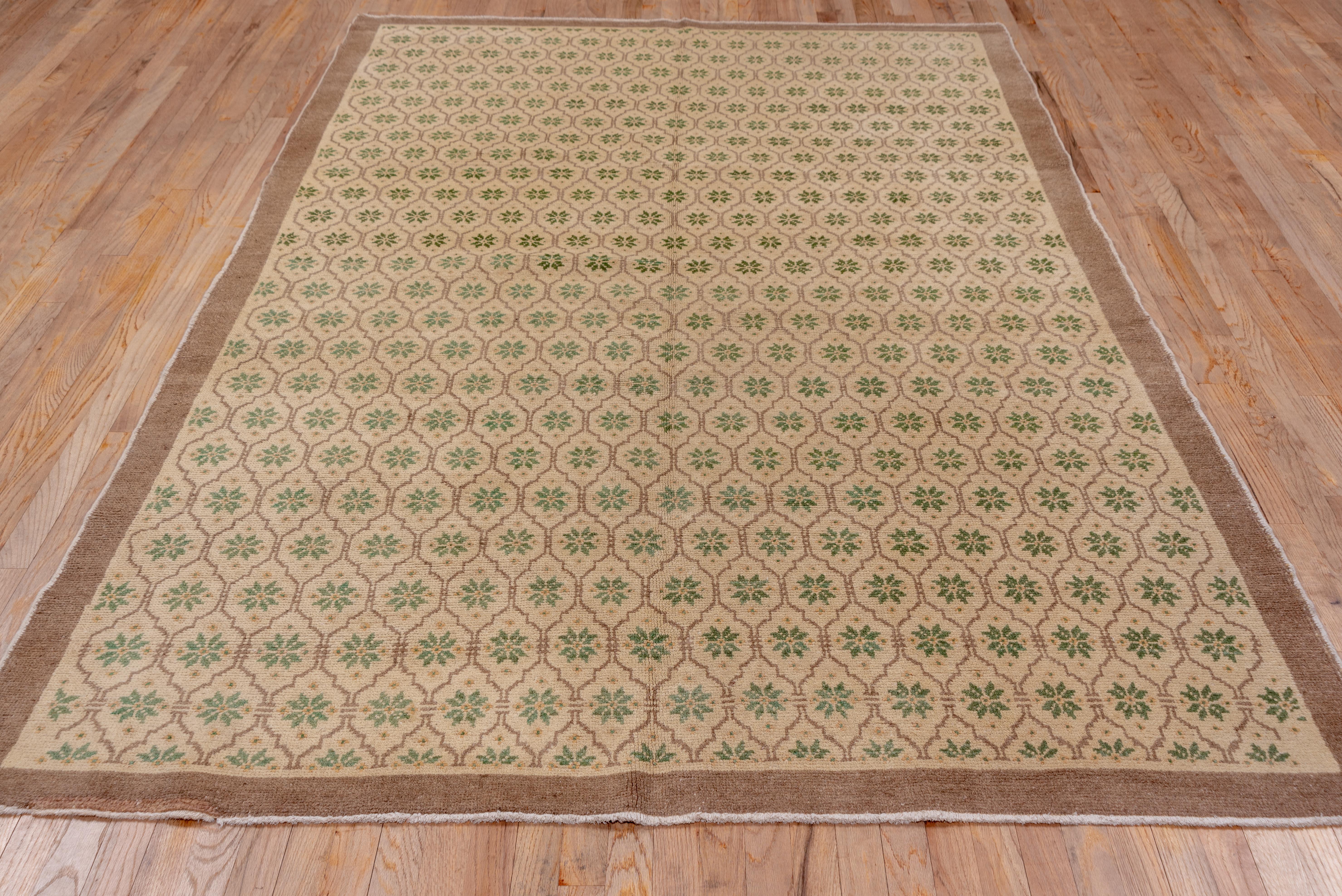 This central Turkish carpet in quite good condition shows a small cartouche all-over textile lattice pattern enclosing eight petal star rosettes on a warm sand -cream ground. A plain camel-tan border frames this mellow carpet.
 