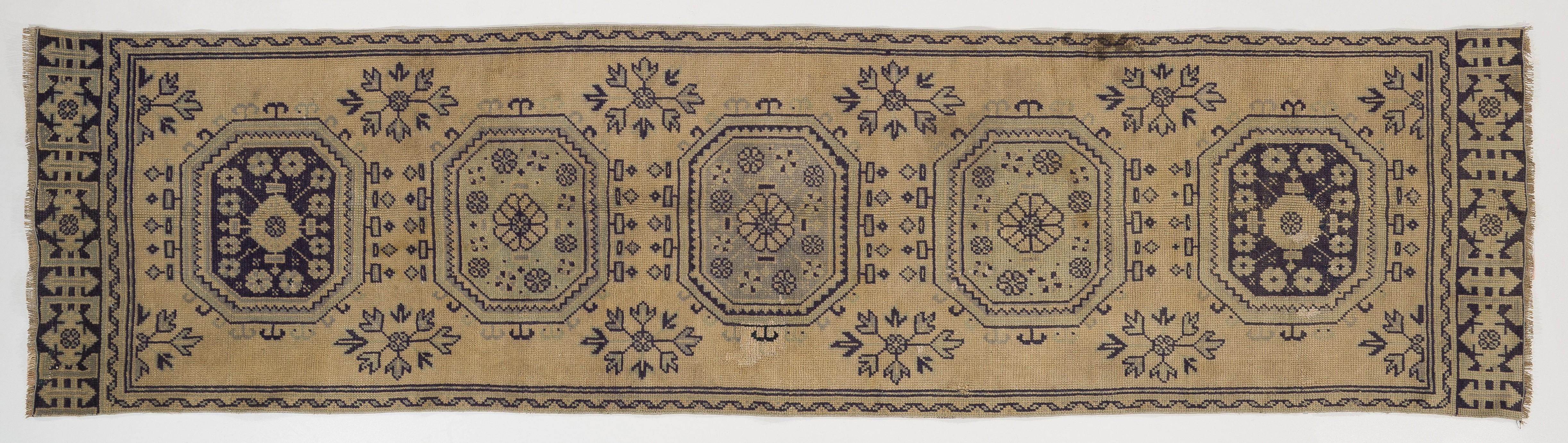 A vintage hand-knotted runner from Central Anatolia.
Medium Wool pile on cotton foundation. 
Beige, dark navy blue, faded soft green colors. 
Good condition, sturdy and as clean as a brand new rug.