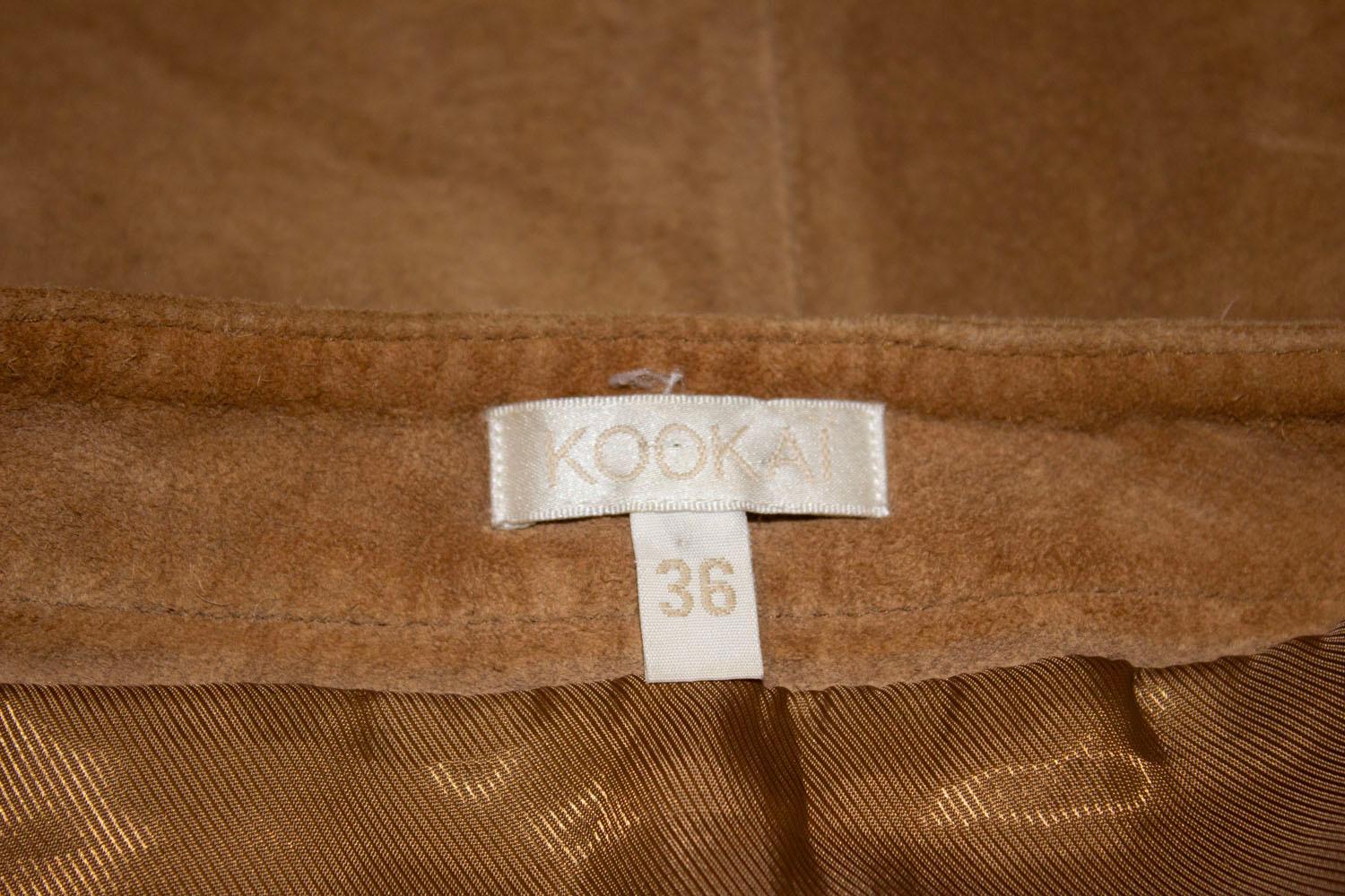 A great vintage suede skirt by French house Kookai. In a light tan colour the skirt has tie detail at the front plus two pockets , a side zip opening and is fully lined. 
Size 36, Measurement Waist 28'', length 23''