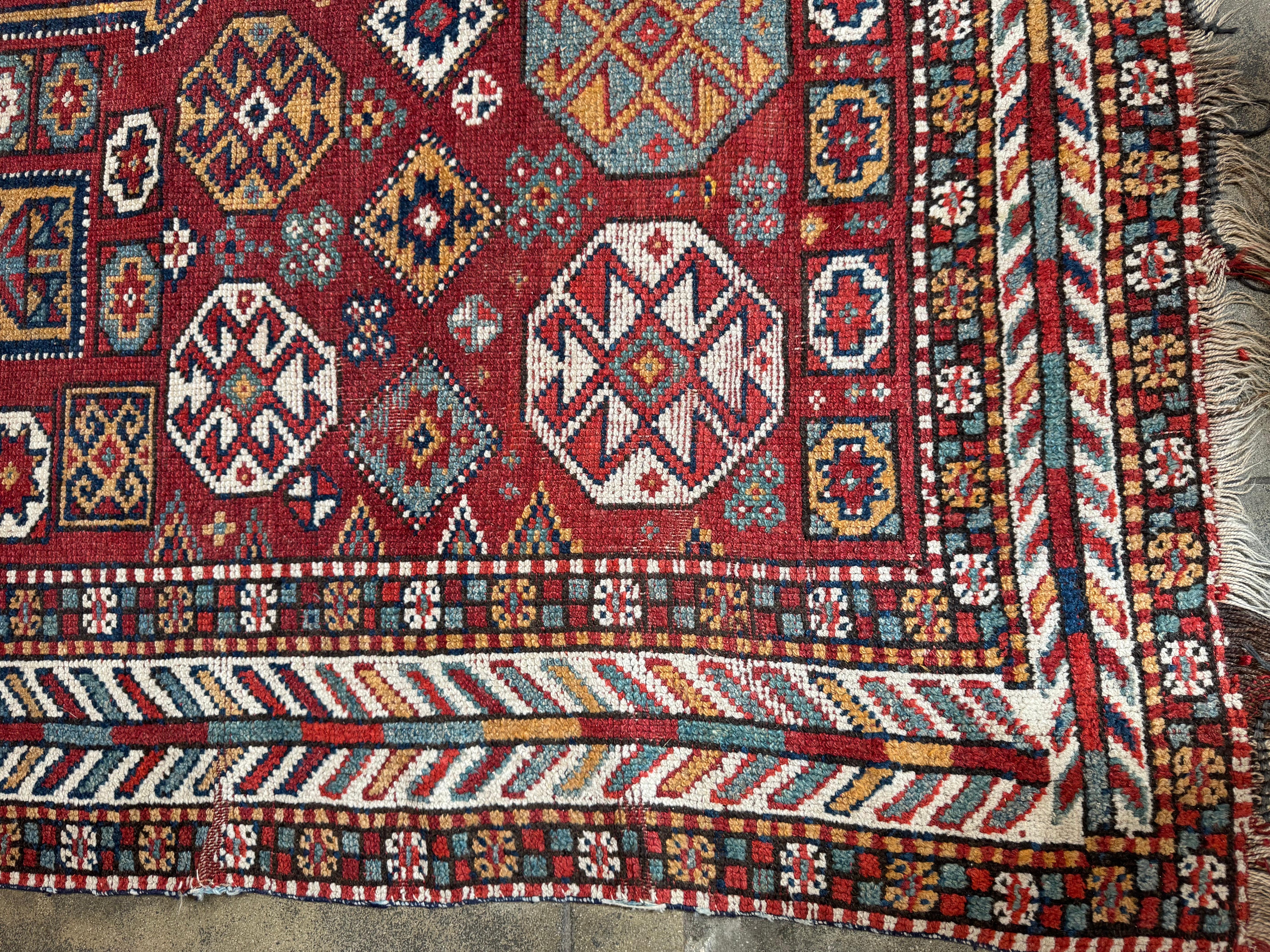 Immergez votre espace dans le riche héritage de ce tapis persan Kordi Ghoochan vintage, un chef-d'œuvre noué à la main et fabriqué par des artisans qualifiés. Tissée en laine de haute qualité, cette pièce remarquable présente un champ rouge vif orné