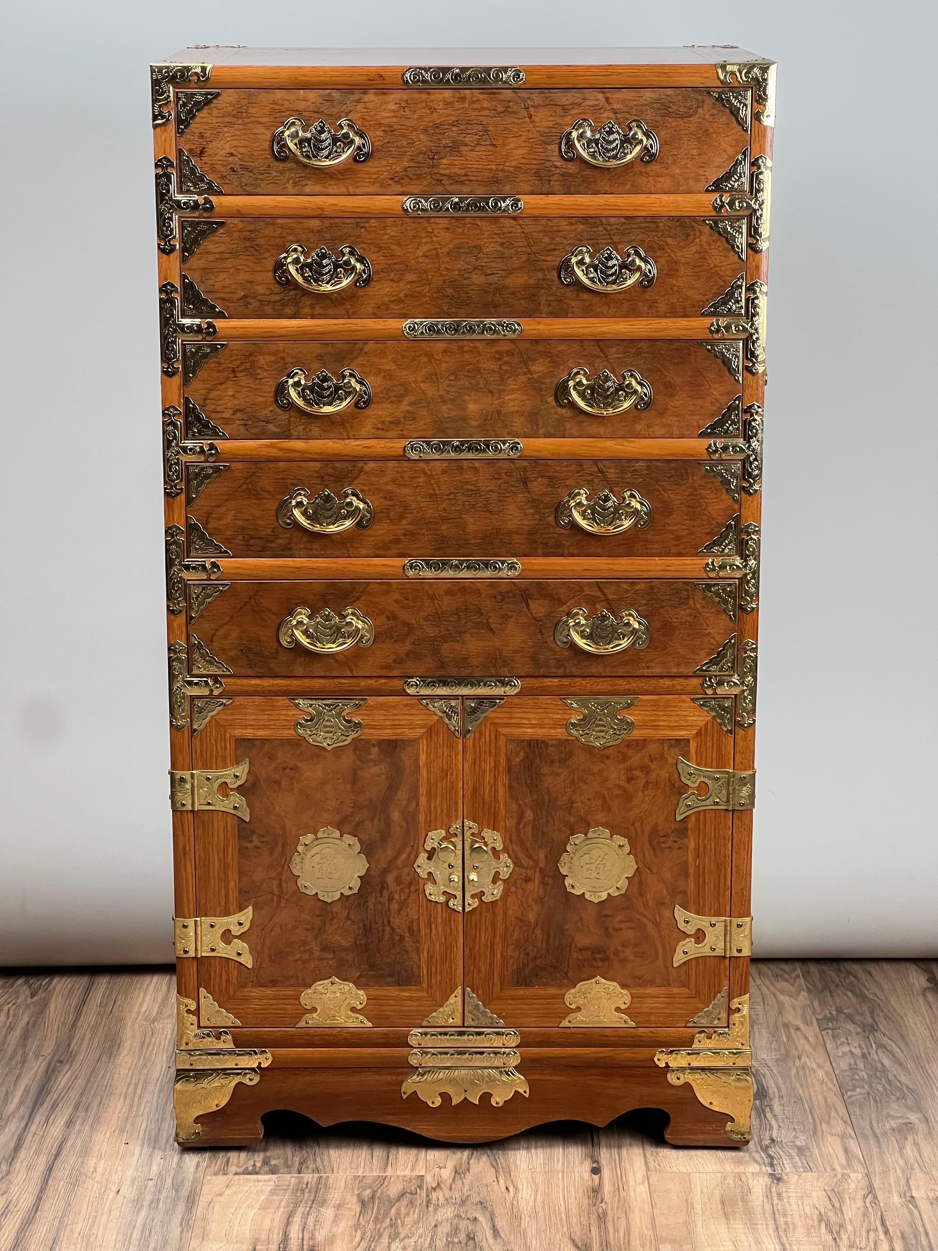 This vintage Korean Bandaji, or scholar’s chest, is crafted from richly figured elm burl and embellished with ornate brass mounts. The form, rooted in traditional Korean furniture design, was used to store valuables, books, and scholarly materials,