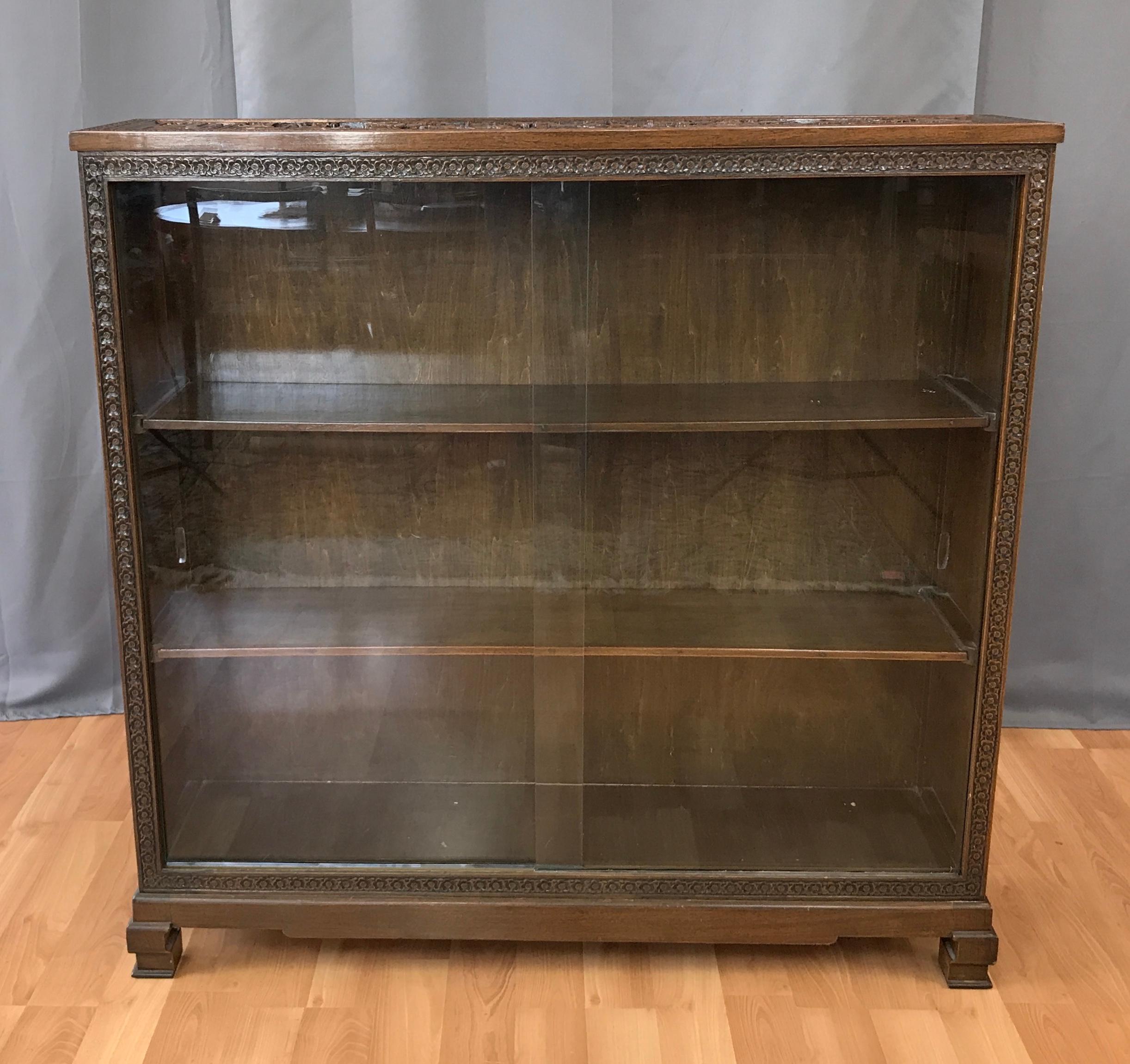 This wonderful vintage Korean Elmwood glass fronted book case has intricately carved top and side panels which feature oriental temples, sail boats, forests, bridges, fishermen and scholars. All bordered by rows of carved flowers which also surround