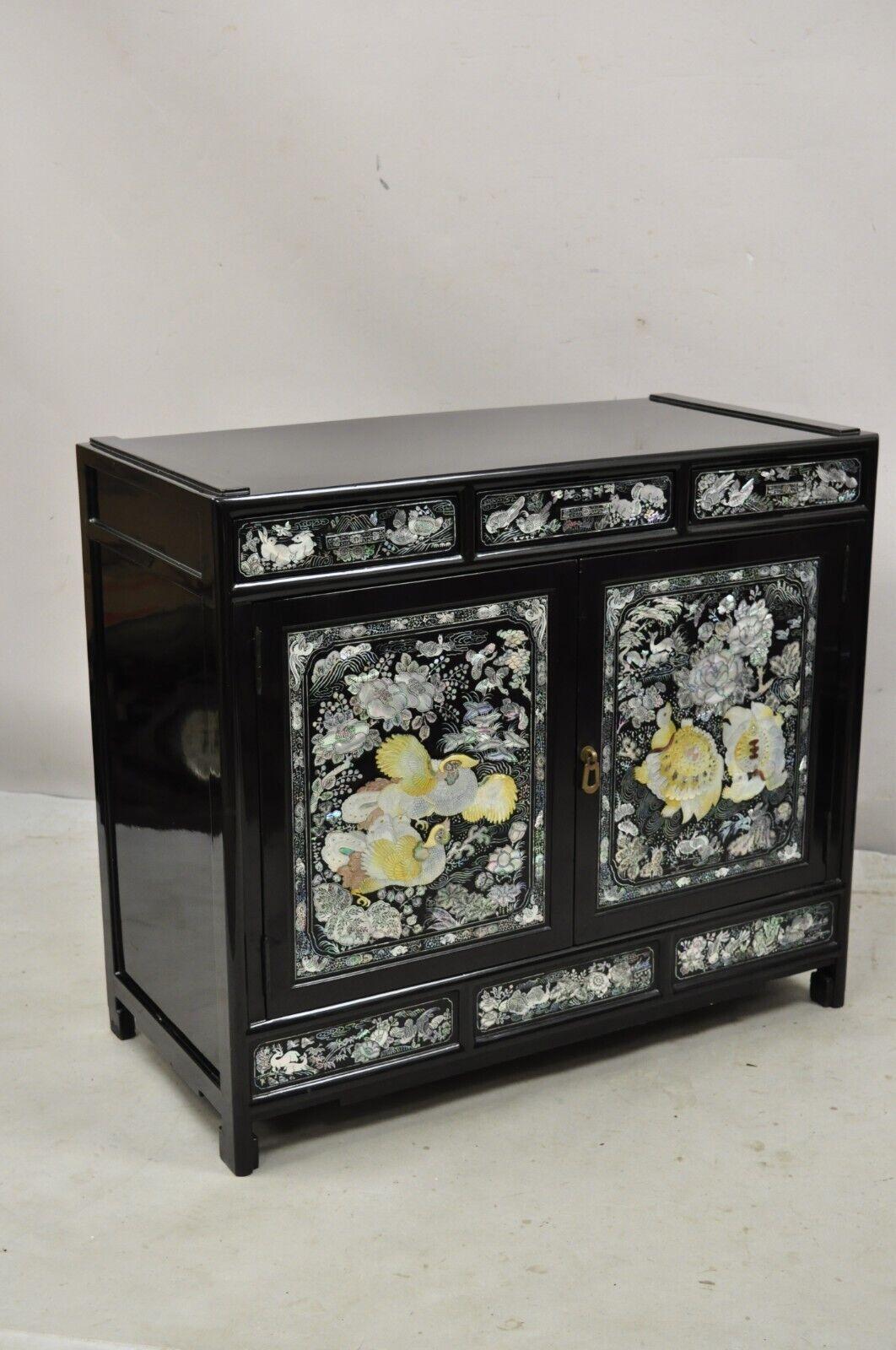Vintage Korean Mother of Pearl oriental black lacquer oriental cabinet. Item features stunning figural, mother of pearl inlay throughout, black lacquer finish, 2 swing doors, 3 drawers, great style and form. circa mid to late 20th century.