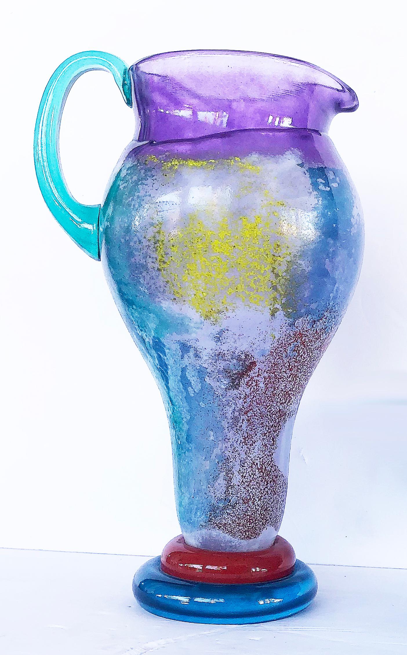Vintage Kosta Boda art glass pitcher by Kjell Engman

 Offered for sale is a blown art glass Kosta Boda pitcher by Kjell Engman. The pitcher is uniquely colored and is signed while retaining the original label on the base. 

The pitcher measures