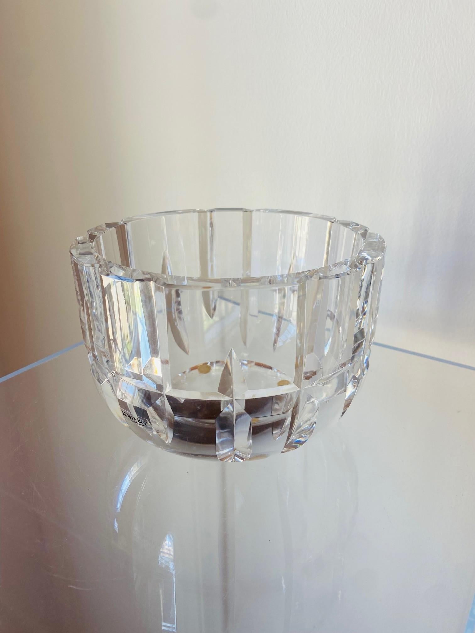 Magnifique et élégante coupe en verre transparent signée Kosta Boda en excellent état, conçue par Goran Warff. La qualité et la coupe brillent à travers cette pièce incroyable qui évoque une force étincelante.  De profondes découpes magistrales dans