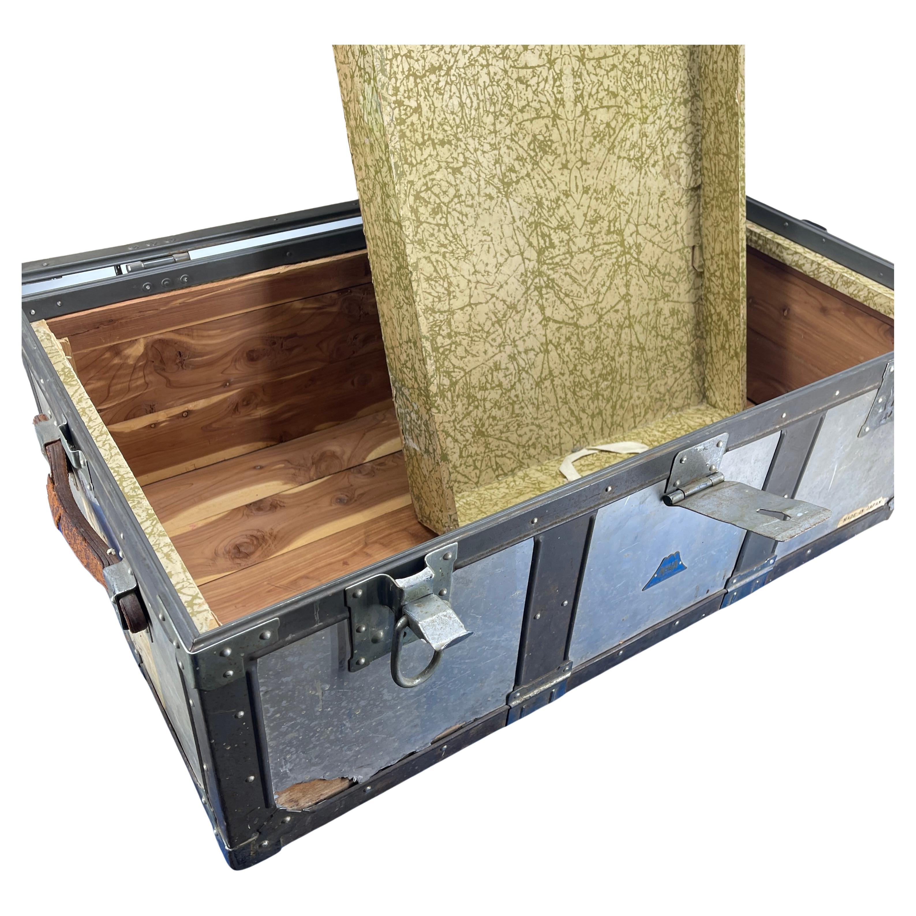 Korean war era military trunk by Kowa. Aluminum body with steel latches and leather handles. This is the real deal, when things were built to last. Stamps along the side reveal the soldier's name and journey. Use this trunk at the base of your bed,