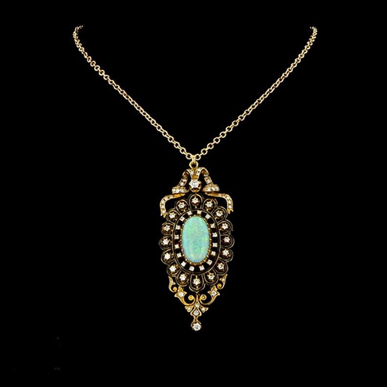 Designed and crafted by American jewelry manufacturer, Krementz & Co., this dazzling pendant was made around 1960 in the style of Victorian Era jewelry. The cabochon opal in the center gleams from within, showing a soft glow of green, coral, and