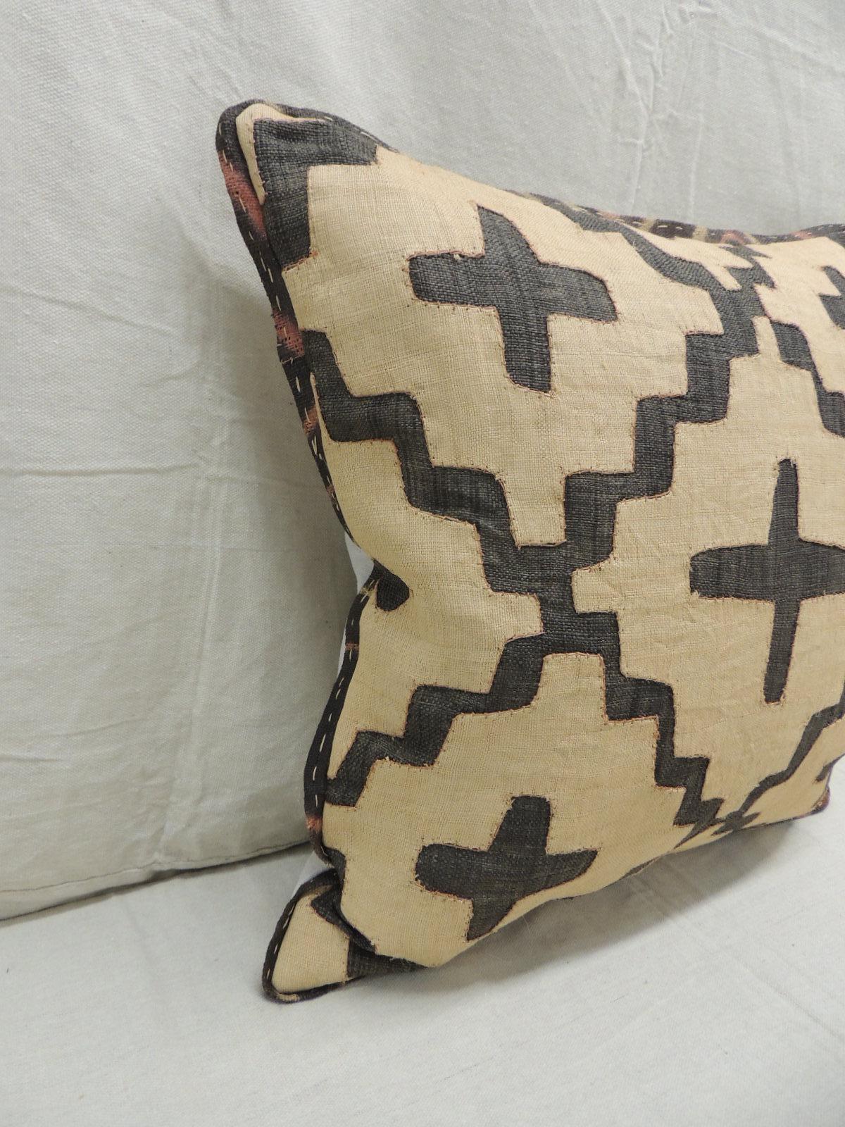 Vintage Kuba tan and black handwoven patchwork African decorative pillow.
Handwoven patchwork and appliqué raffia African decorative lumbar pillow with labyrinth pattern.
We used the original textile frame as a trim all around the pillow. Light gris