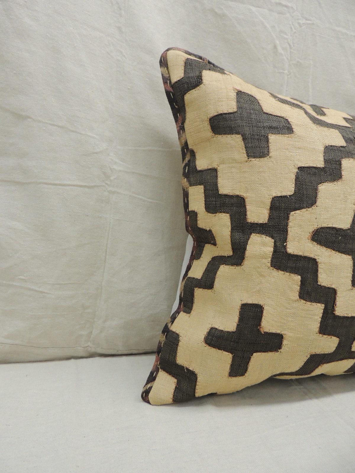 Vintage kuba tan and black handwoven patchwork African decorative pillow.
Handwoven patchwork and appliqué raffia African decorative lumbar pillow with labyrinth pattern.
We used the original textile frame as a trim all around the pillow. Light