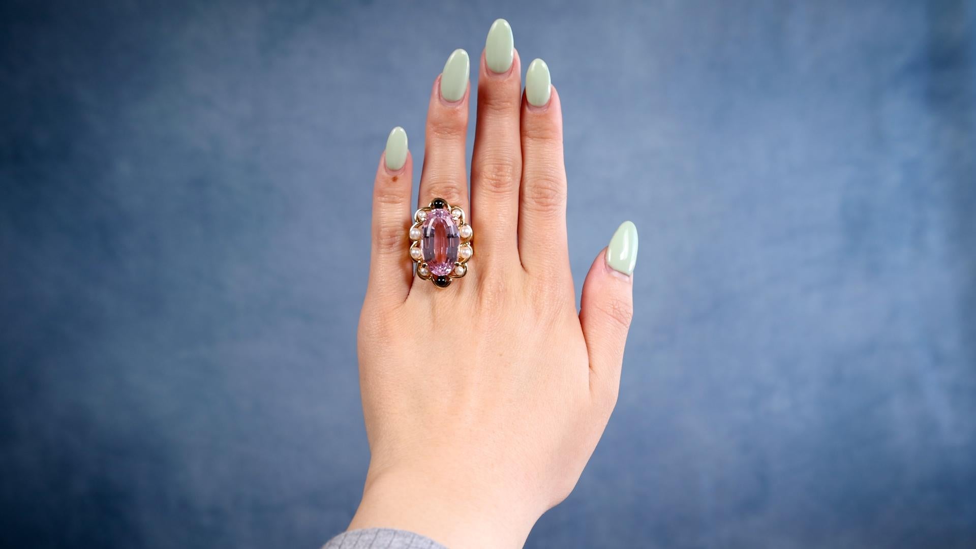 Une bague de cocktail vintage en or jaune 18k avec perles de kunzite et onyx. Elle contient une kunzite ovale de 11,50 carats. Elle est rehaussée de huit perles mesurant environ 3,10 à 4,00 millimètres et de deux morceaux d'onyx poli. Fabriqué en or