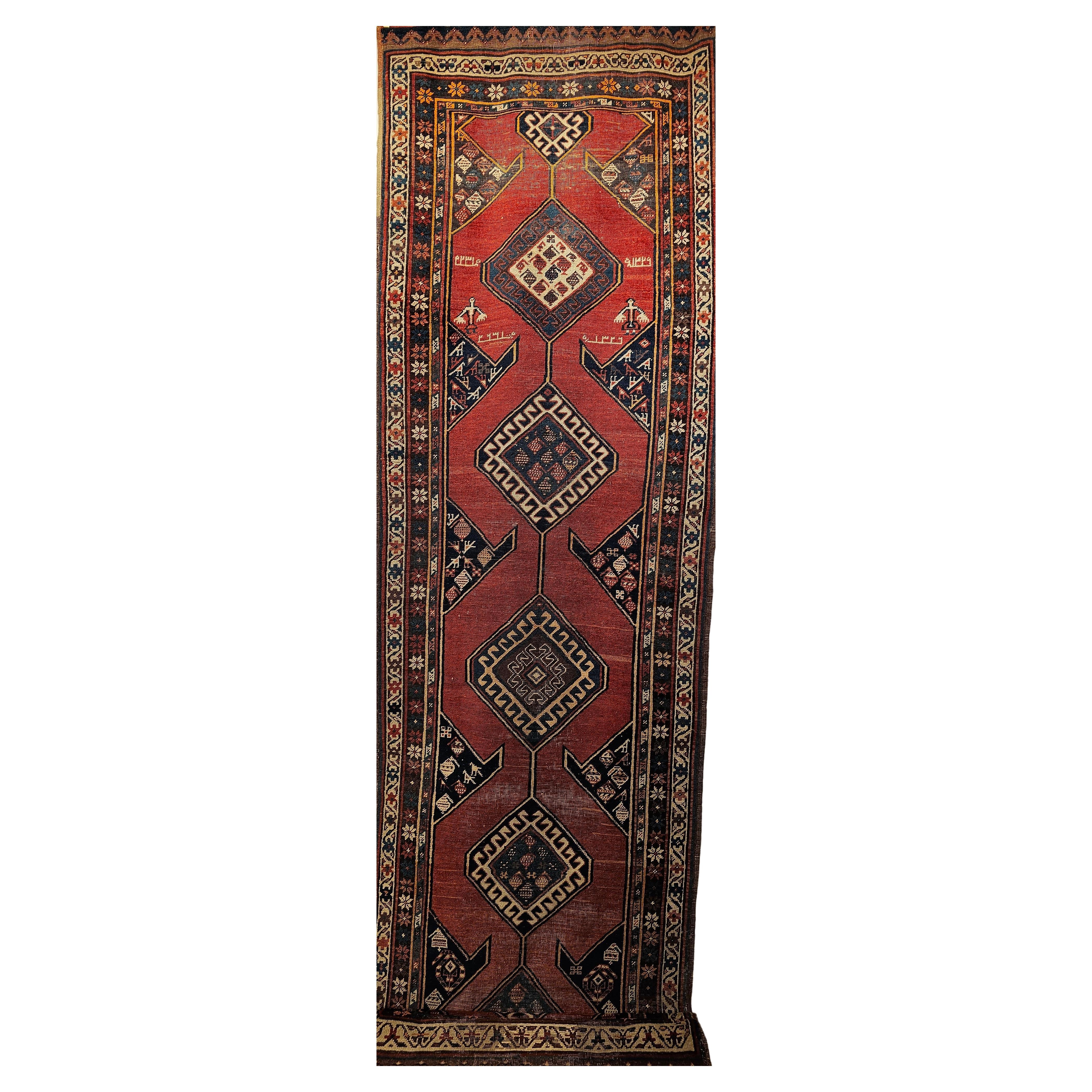A vintage Kurdish Bidjar runner in a geometric medallion pattern set on an abrash terracotta red field color from the early 1900s.  There are five medallions in the field connected via a line ending in a smaller medallion on each end. The border