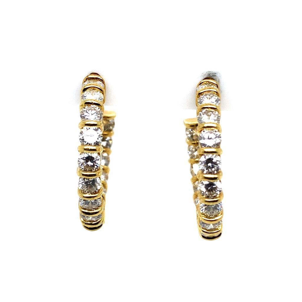 A pair of vintage Kutchinsky 18 karat yellow gold diamond hoop earrings, circa 1970.

With thirty two round brilliant cut diamonds totalling 2.56cts assessed as G/H colour, VS/S1 clarity, tension set along the outer curve and intricately set to the