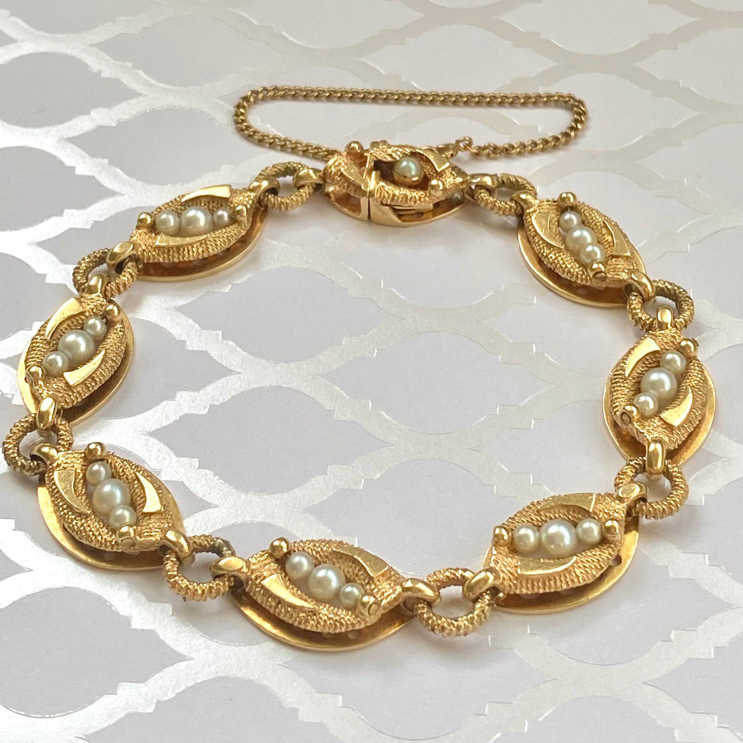 Armband La Triomphe 14K, bestehend aus einer Reihe von länglichen Goldgliedern, die durch Goldreifen verbunden sind. Jedes Glied ist mit drei weißen Perlen besetzt. Der Kontrast von hellem und strukturiertem Finish verleiht dieser Vintage-Schönheit