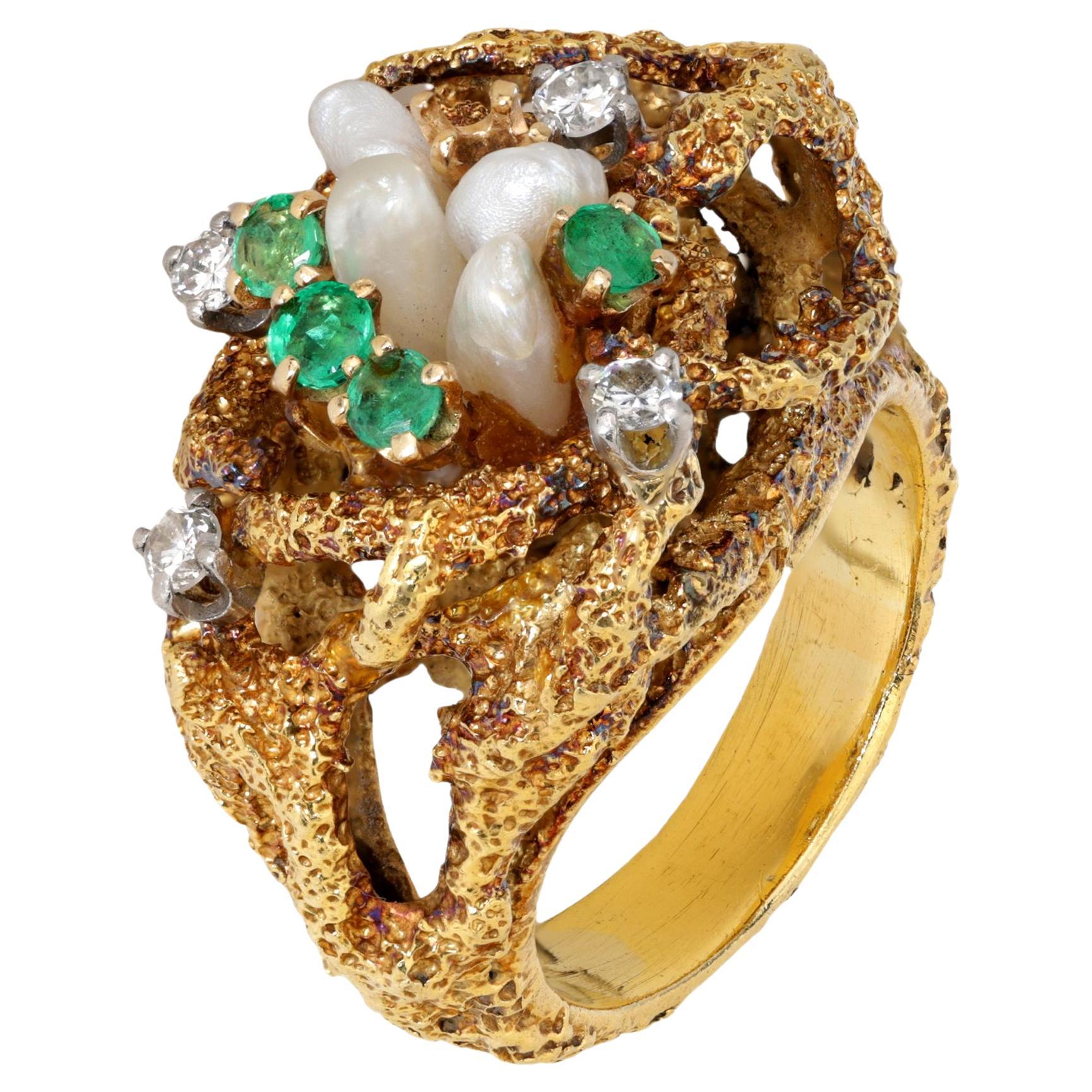 This vintage La Triomphe 18k yellow gold ring showcases four lustrous pearls, accented by four vibrant round emeralds totaling approximately 0.30 carats and four round brilliant cut diamonds totaling approximately 0.20 carats, G-H color, VS clarity.