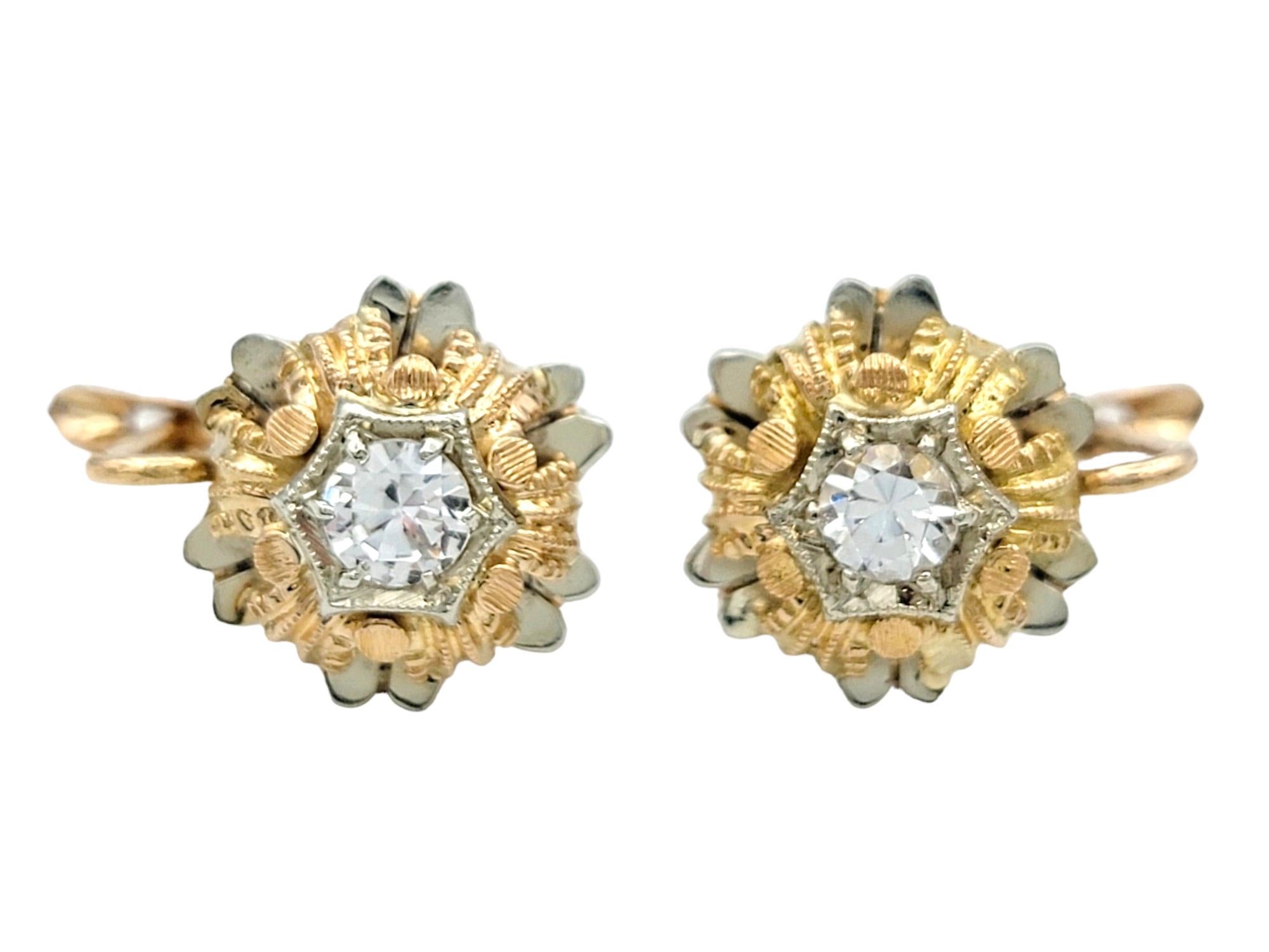 These captivating earrings, set in a luxurious combination of 18 karat yellow and white gold, boast a mesmerizing design that elegantly showcases a lab-created colorless round spinel at its center. The intricate metalwork surrounding the spinel